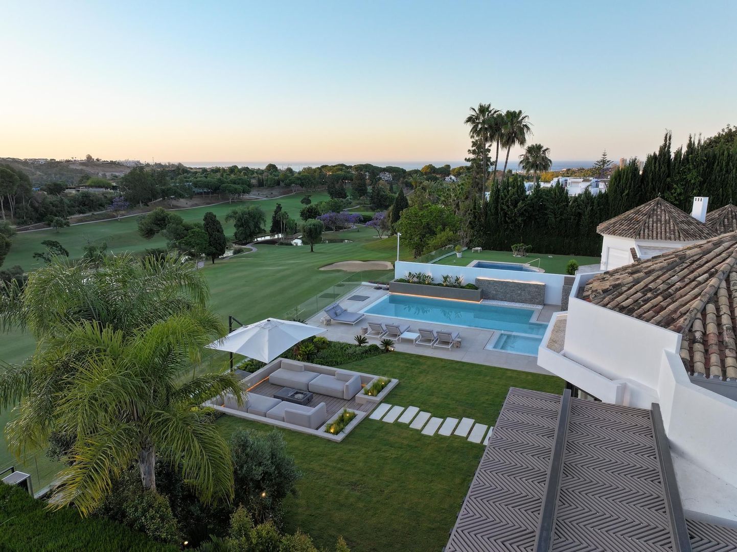 Elevated exterior view over the gardens and pool terrace of Villa Aquila with surrounding landscape beyond