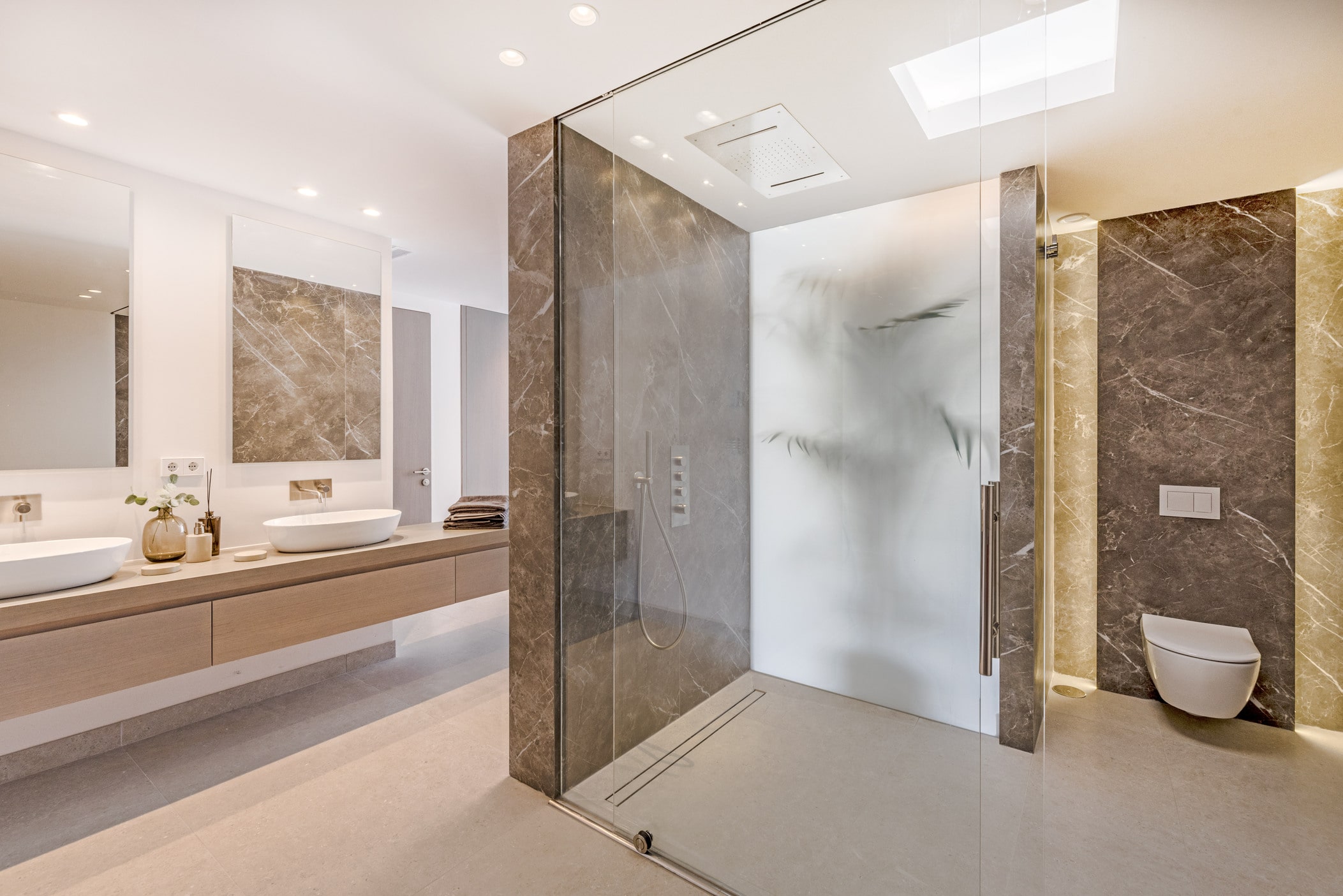 Main bathroom at Villa Aquila with vanity, stone shower enclosure and calm contemporary material palette