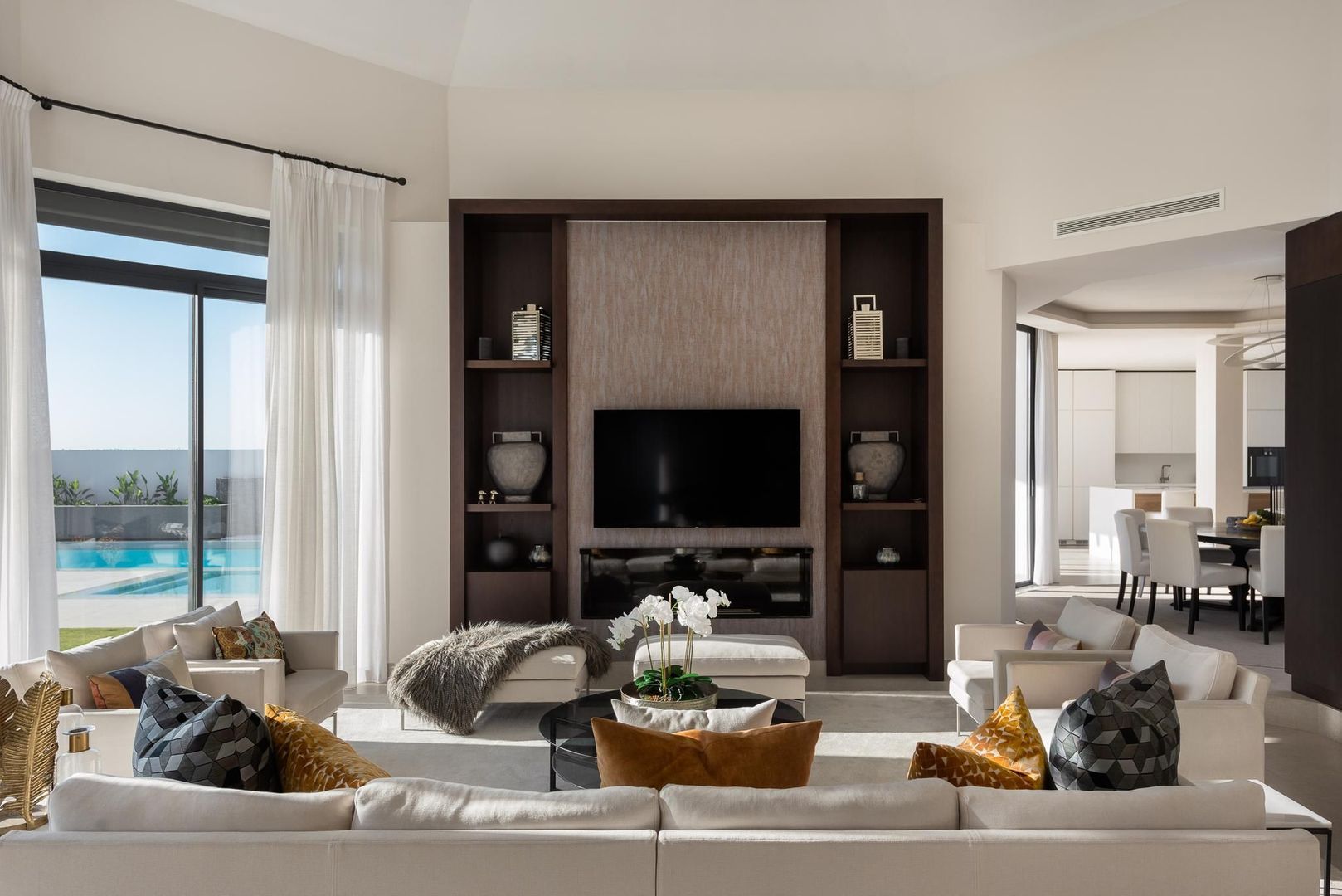 Main living room at Villa Aquila with fireplace wall, shelving and direct connection to the outdoor terrace