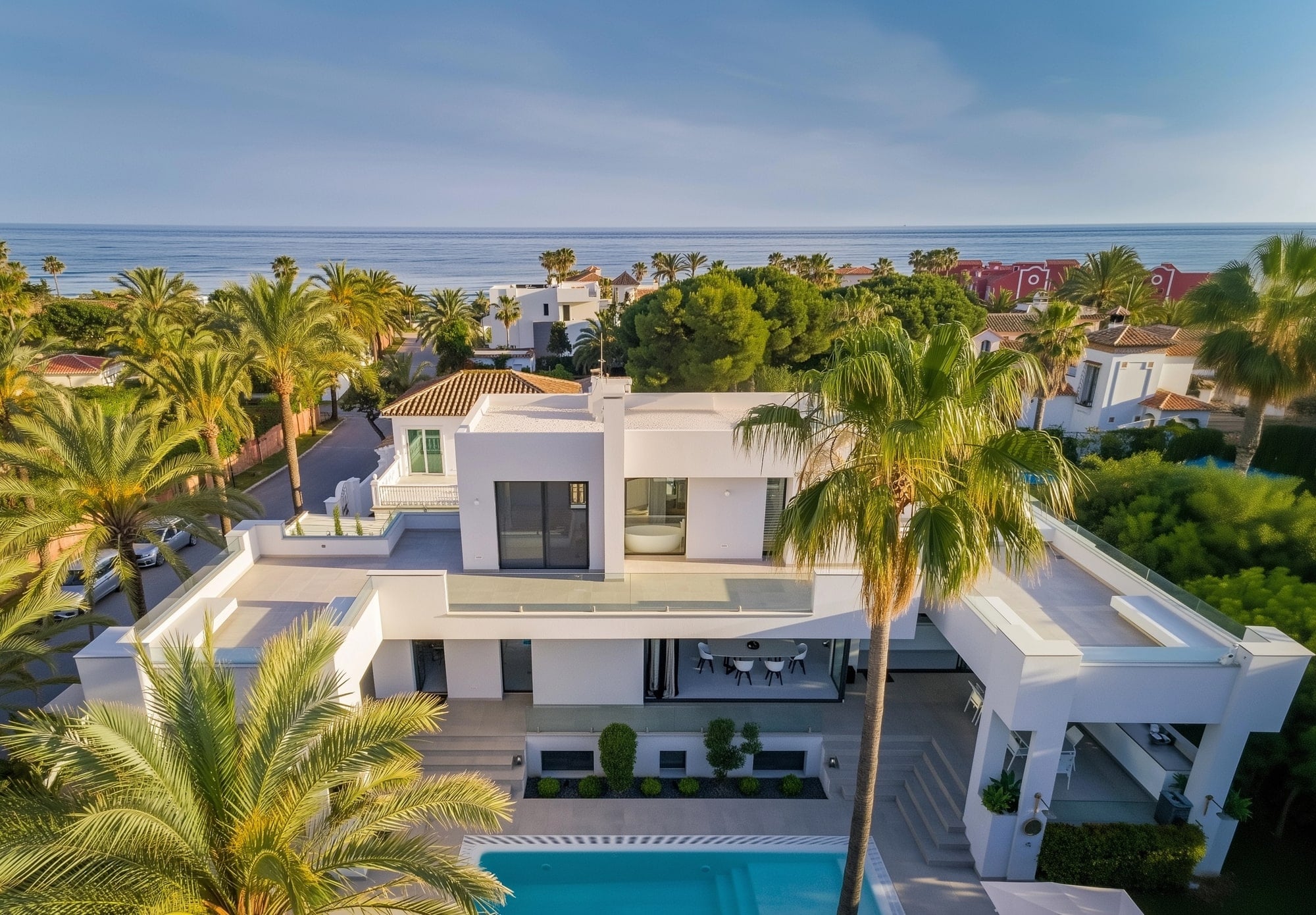 Aerial exterior view of Villa Australia with white architecture, pool terrace and surrounding palm landscape in Marbella East