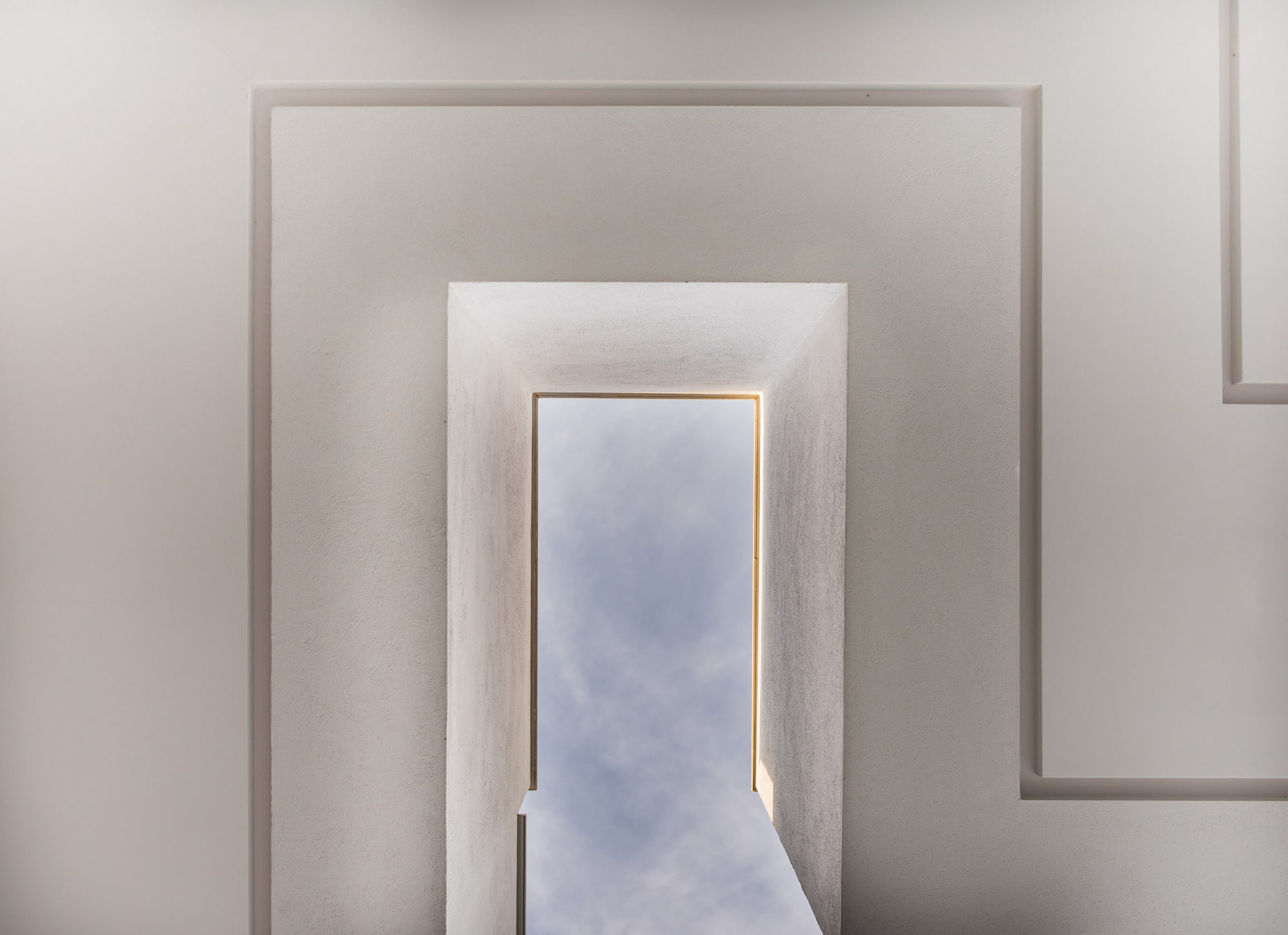 Minimal corridor sequence at Villa Australia with sculpted wall openings and soft architectural light