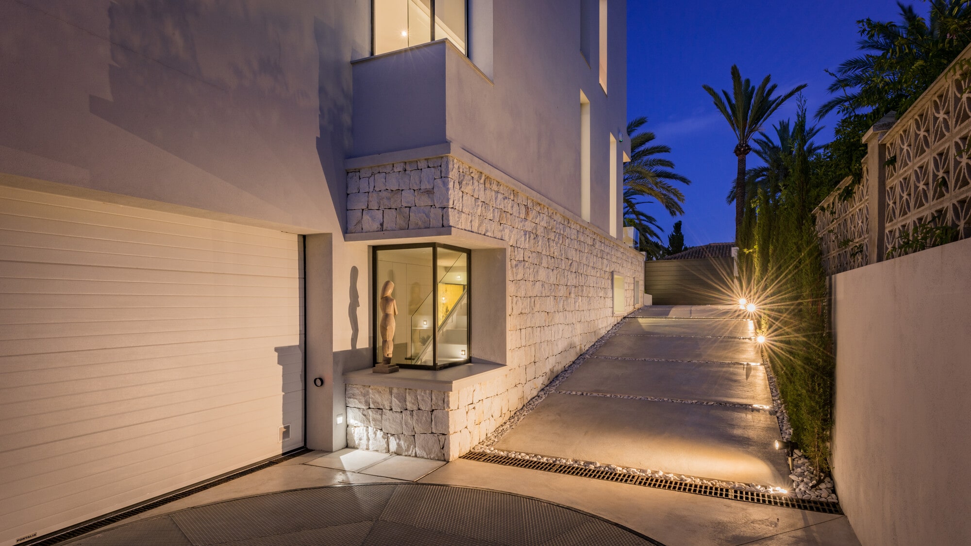 Twilight driveway and entrance approach at Villa Australia with soft architectural lighting and premium residential atmosphere