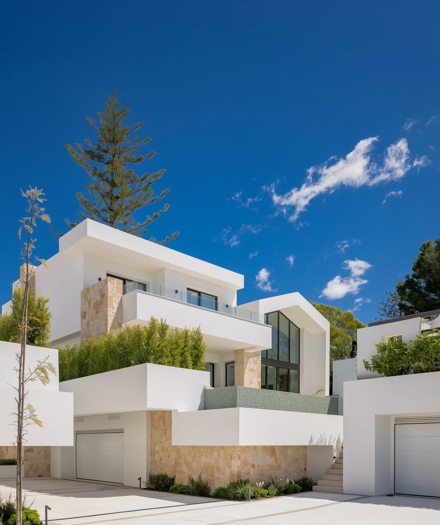 White contemporary villa volumes framed by tropical landscaping