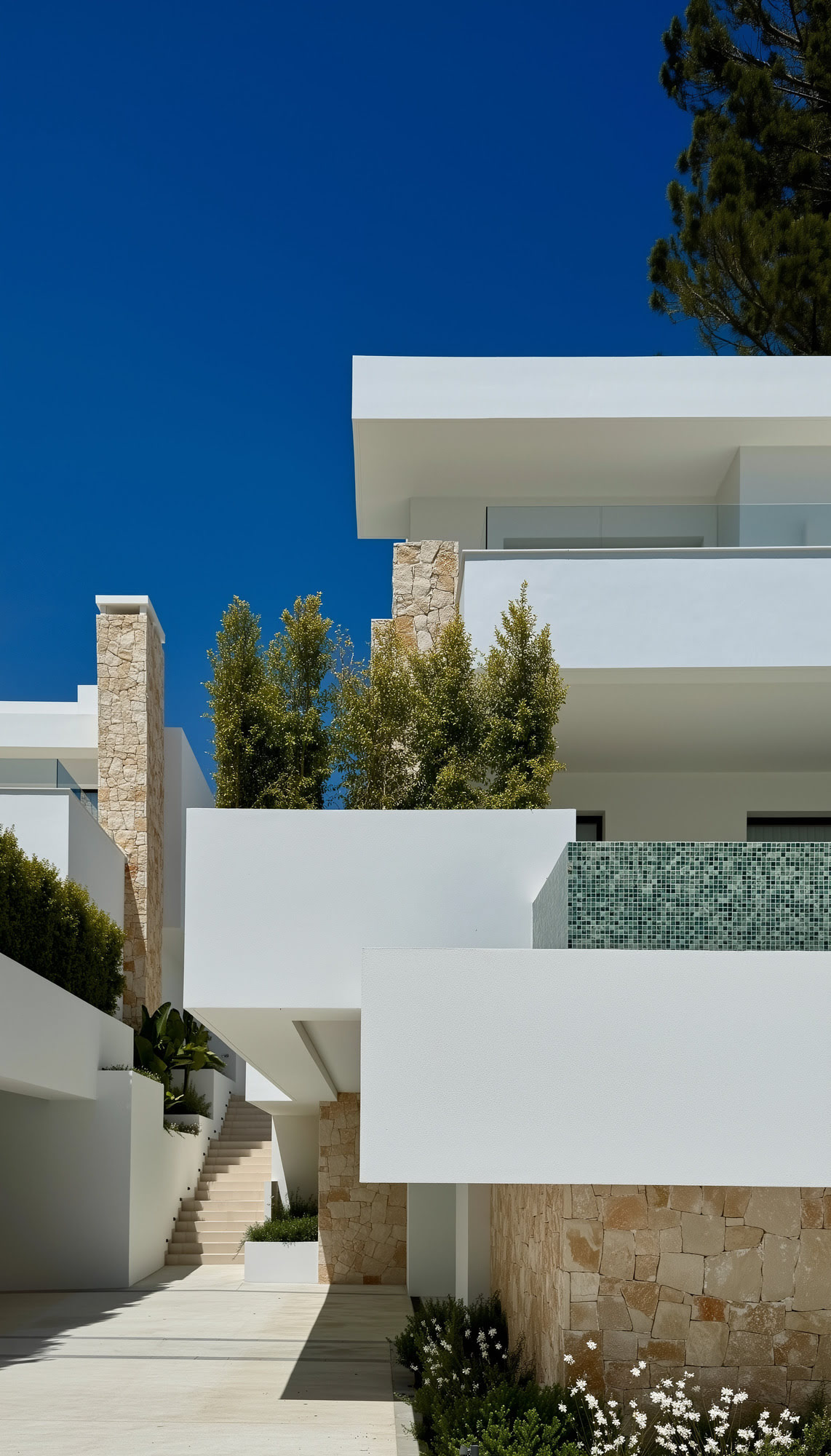 Side façade with layered terraces and Mediterranean vegetation