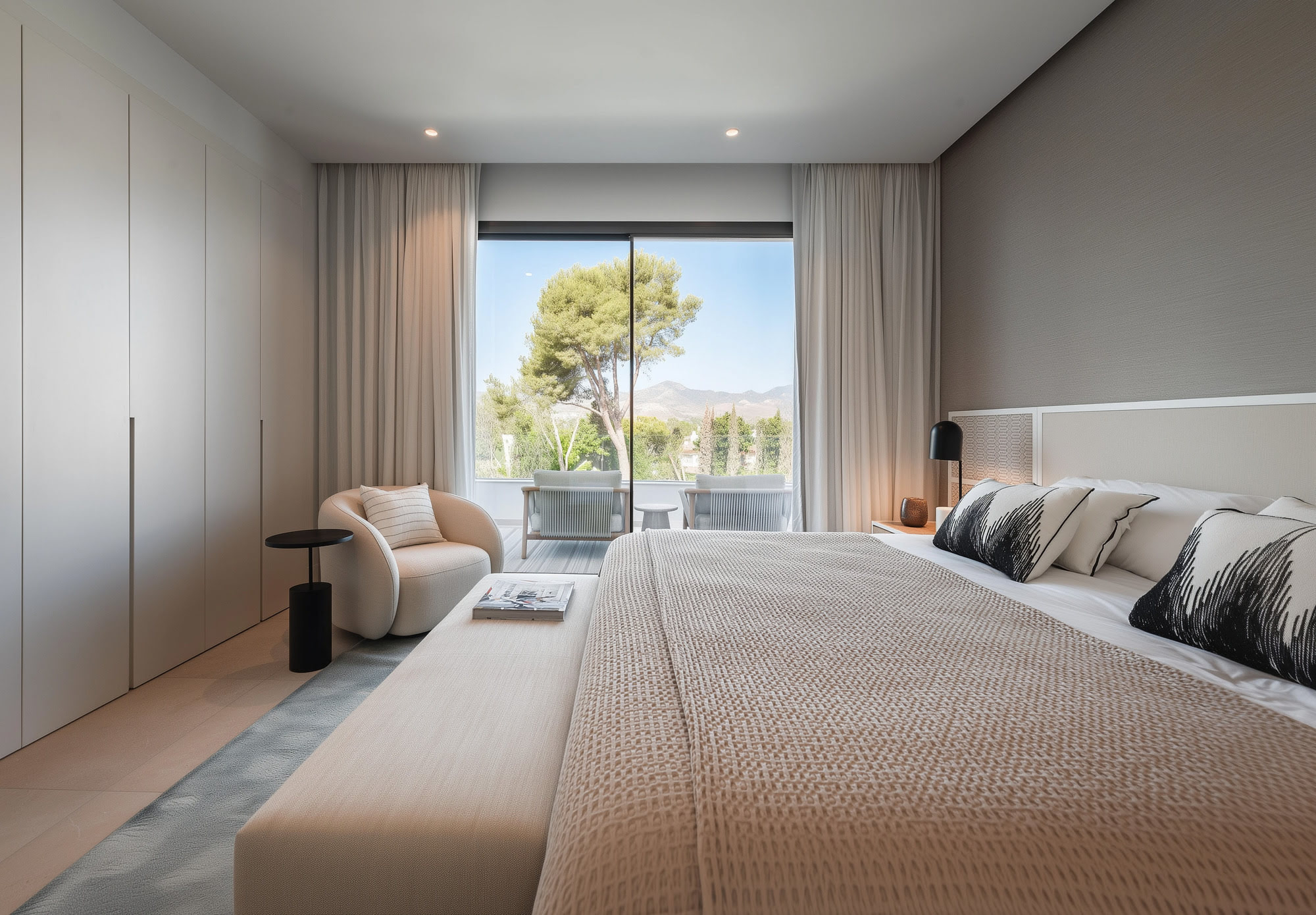 Bedroom with neutral palette and large window overlooking the landscape