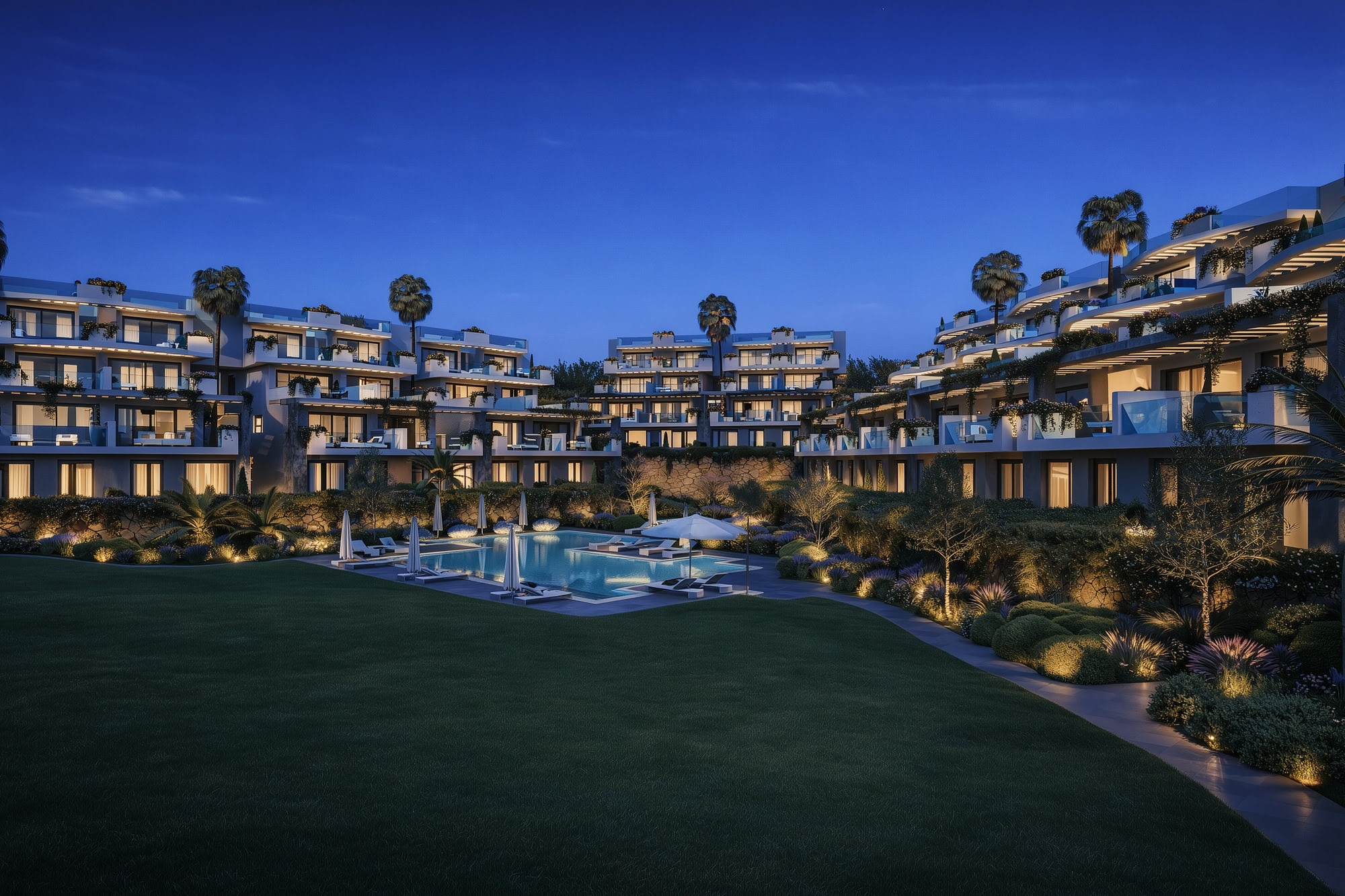 Twilight general view of CALASOL with illuminated terraces and landscaped central garden