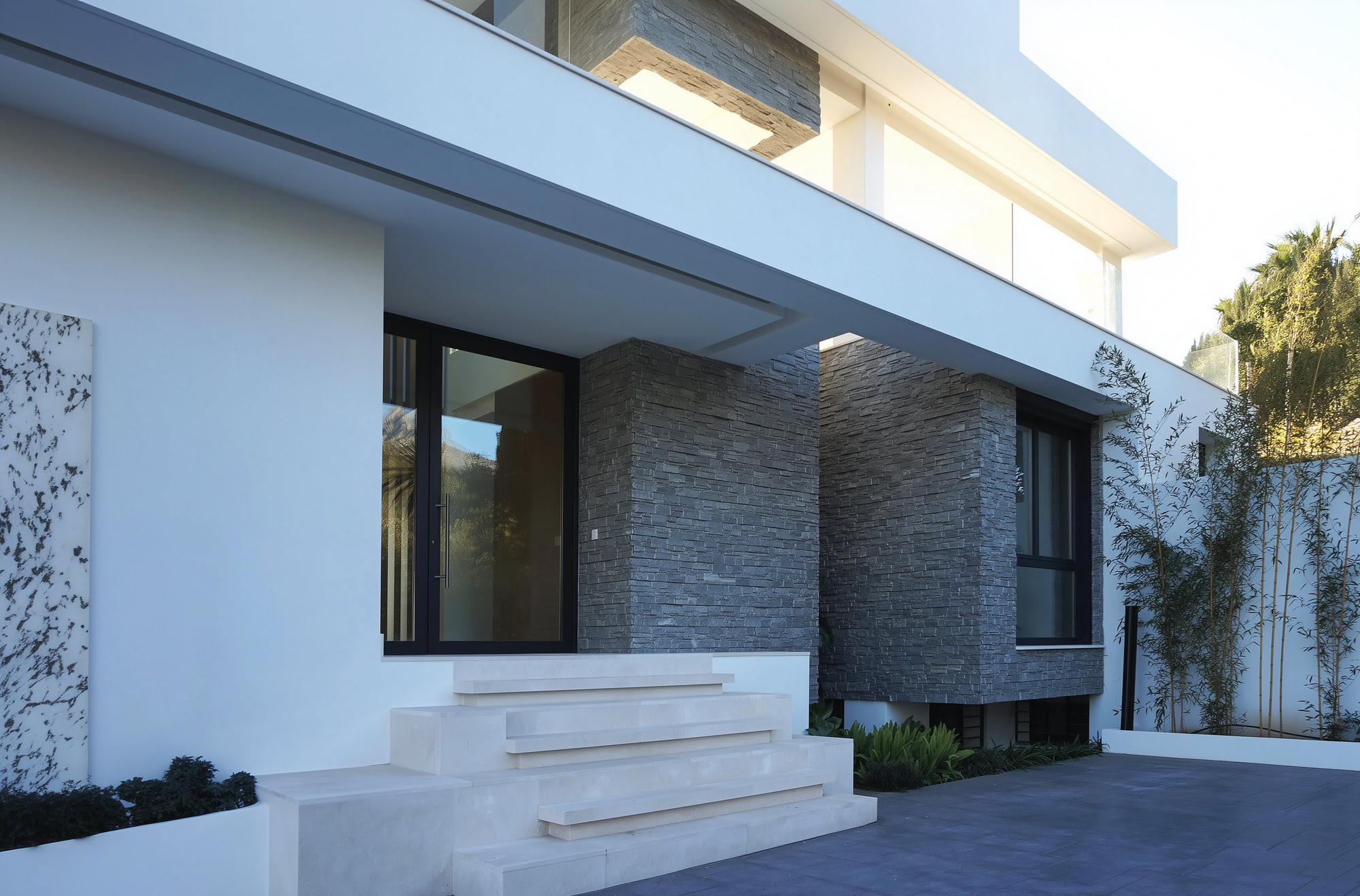 Villa Casalina main entrance sequence with stone cladding, white render and warm contemporary detailing