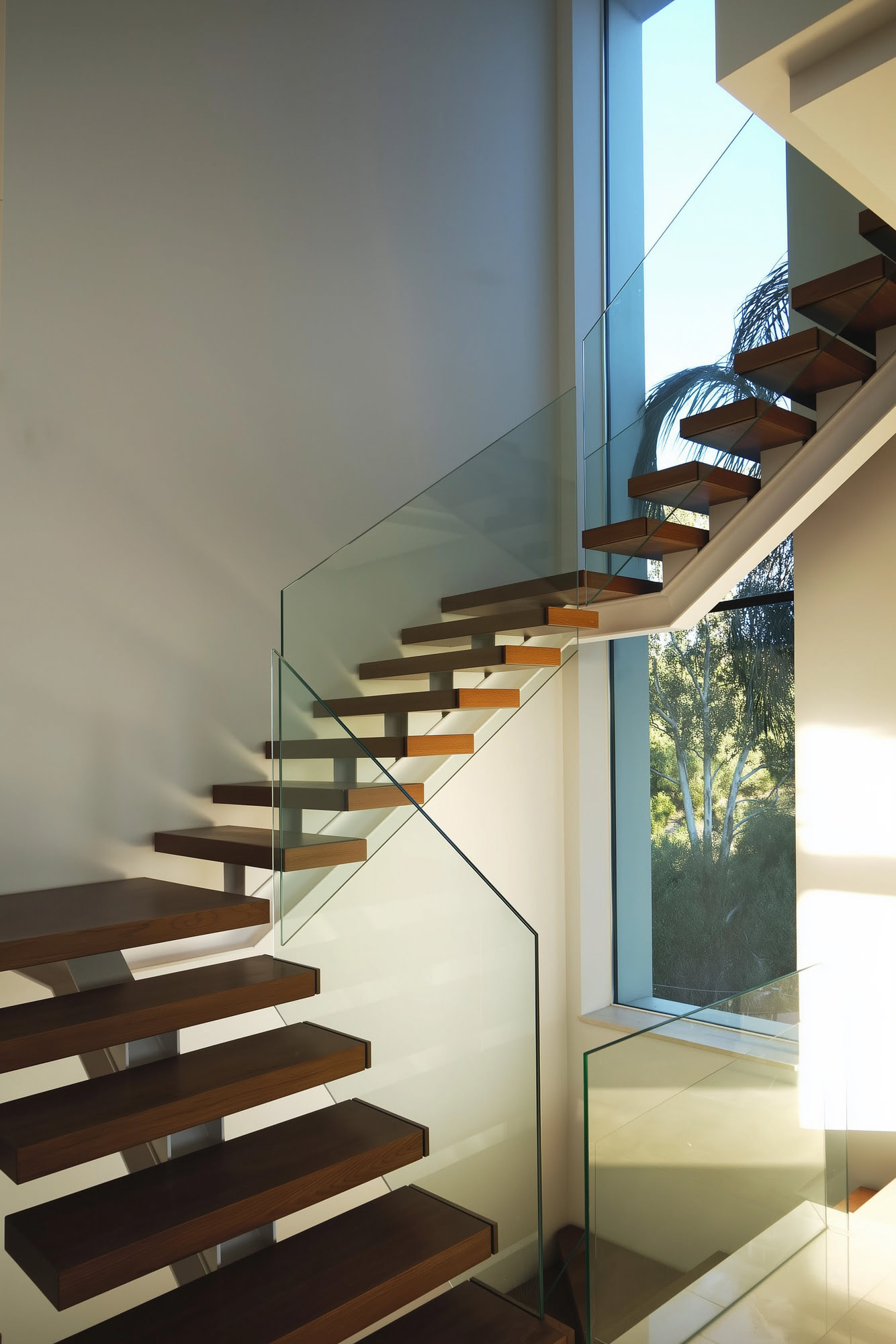 Villa Casalina floating staircase with timber treads, glass balustrade and double height light well