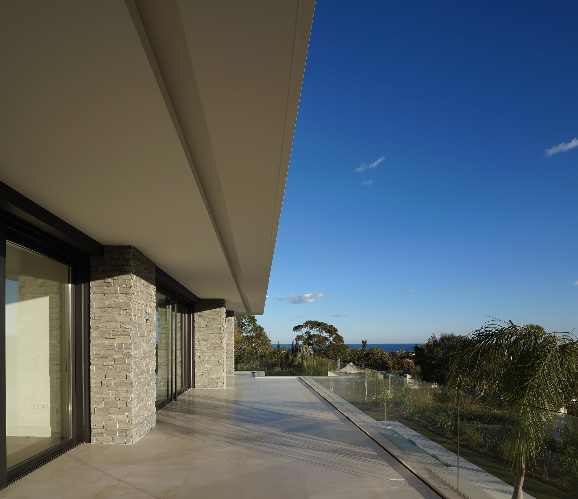 Villa Casalina covered terrace perspective with deep overhang, stone wall and open landscape views