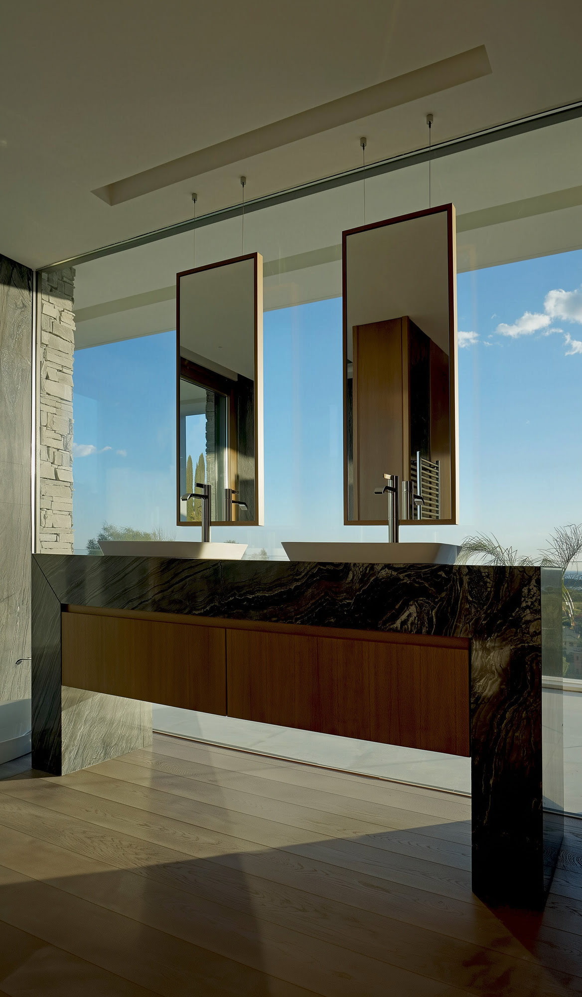 Villa Casalina interior bathroom perspective with warm wood cabinetry, reflective surfaces and open views