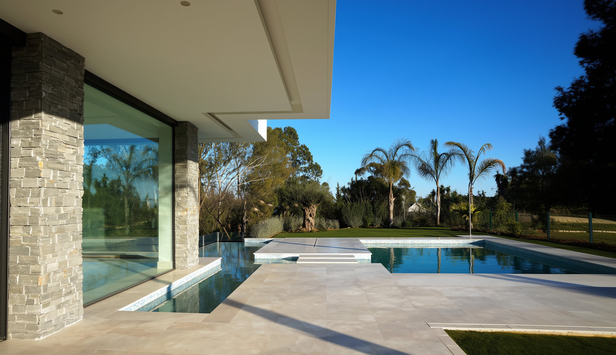 Villa Casalina poolside terrace seen from interior, merging outdoor water, lounge space and architecture