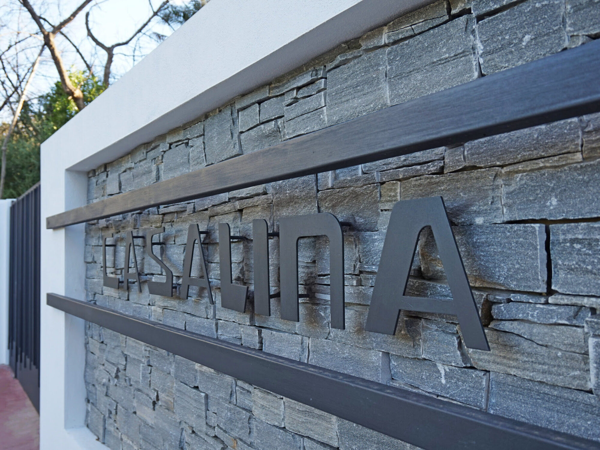 Villa Casalina stone signage detail at entrance, expressing project identity and crafted materiality