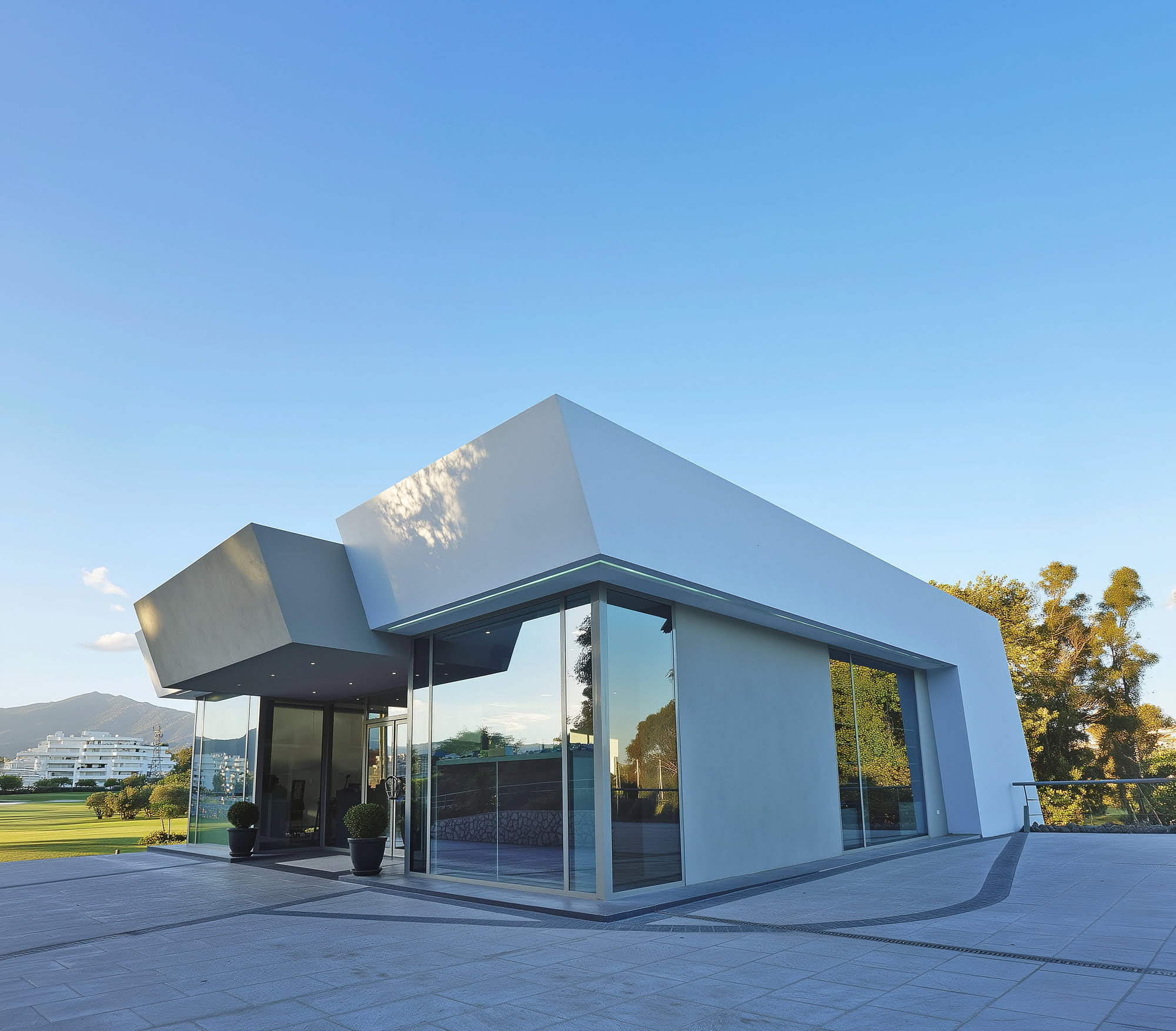 Corner perspective of the R.C. Golf Guadalmina pavilion with crisp glazing and faceted white volume