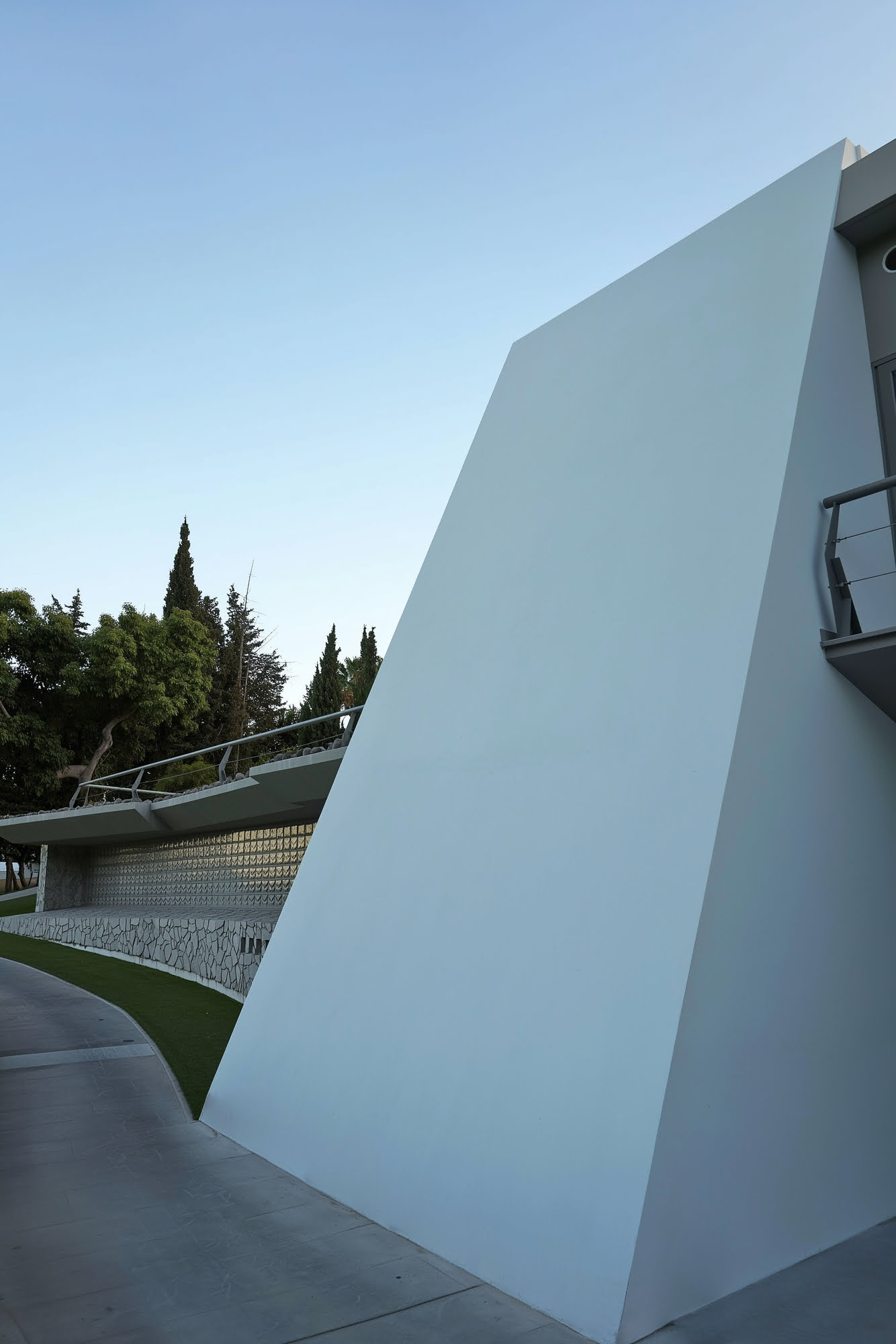 Monolithic sculptural wall of the clubhouse defining the circulation route around the building