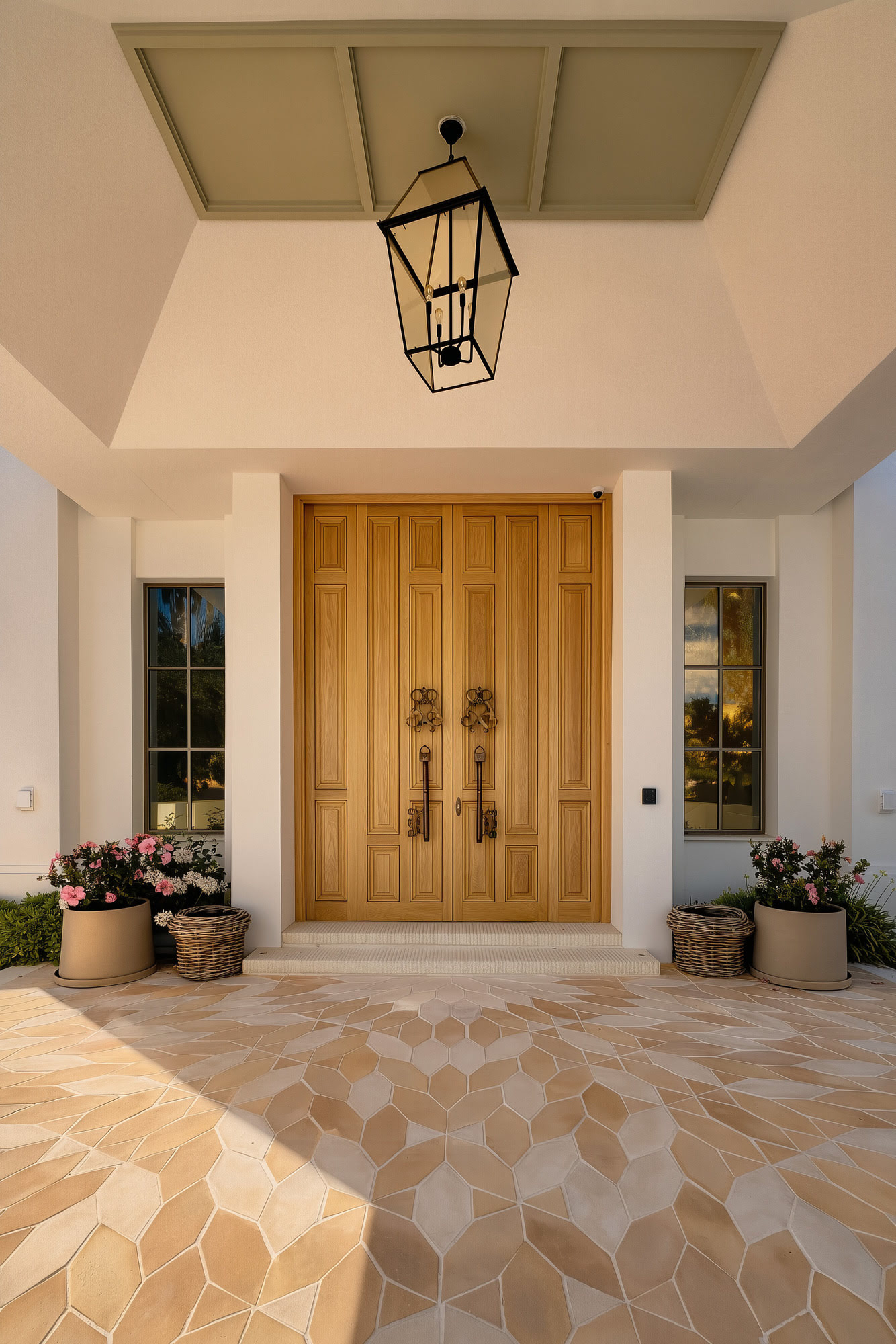Main entrance porch with timber door, lantern and patterned stone paving at Villa Diva
