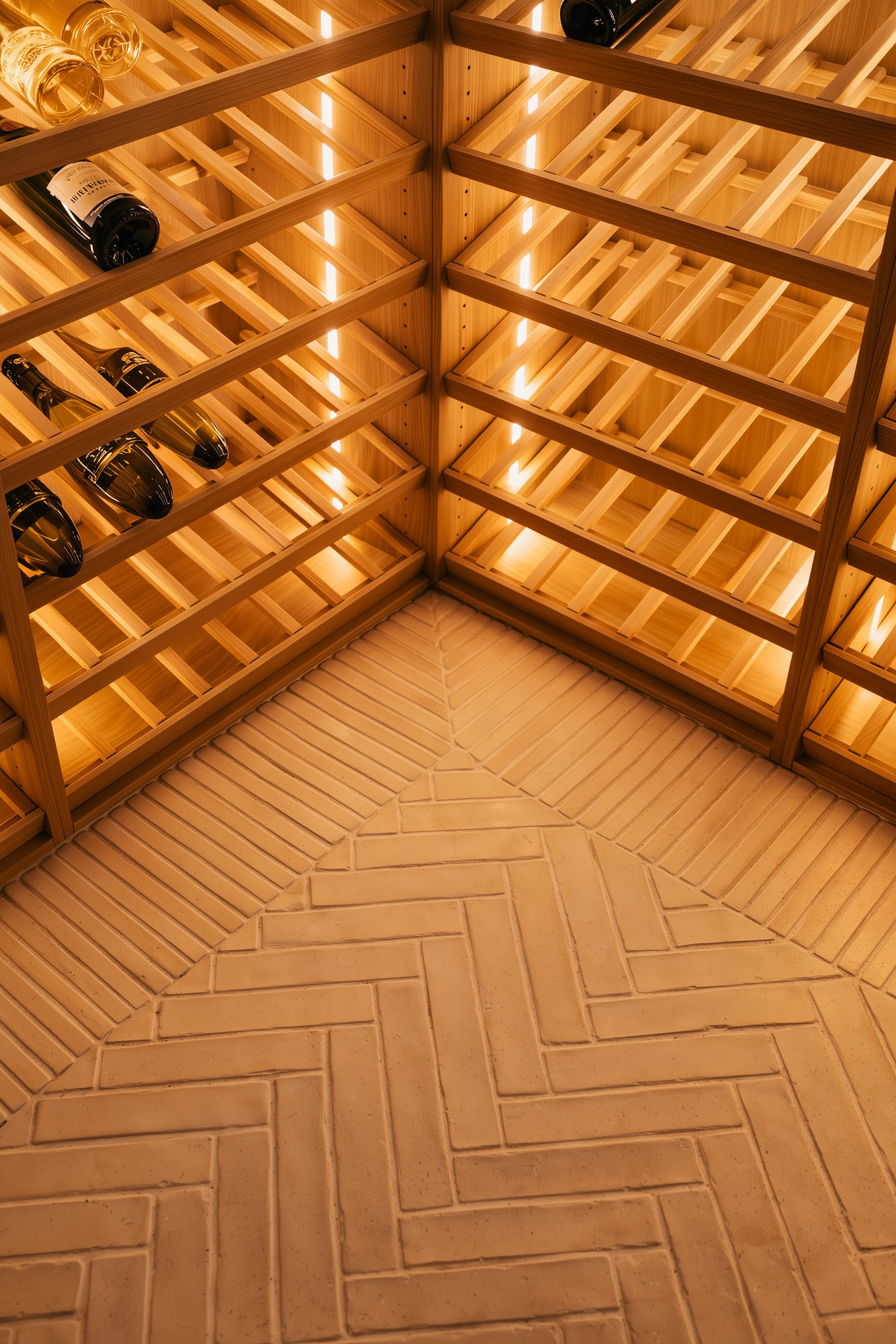 Custom timber wine cellar at Villa Diva with herringbone floor and integrated warm lighting