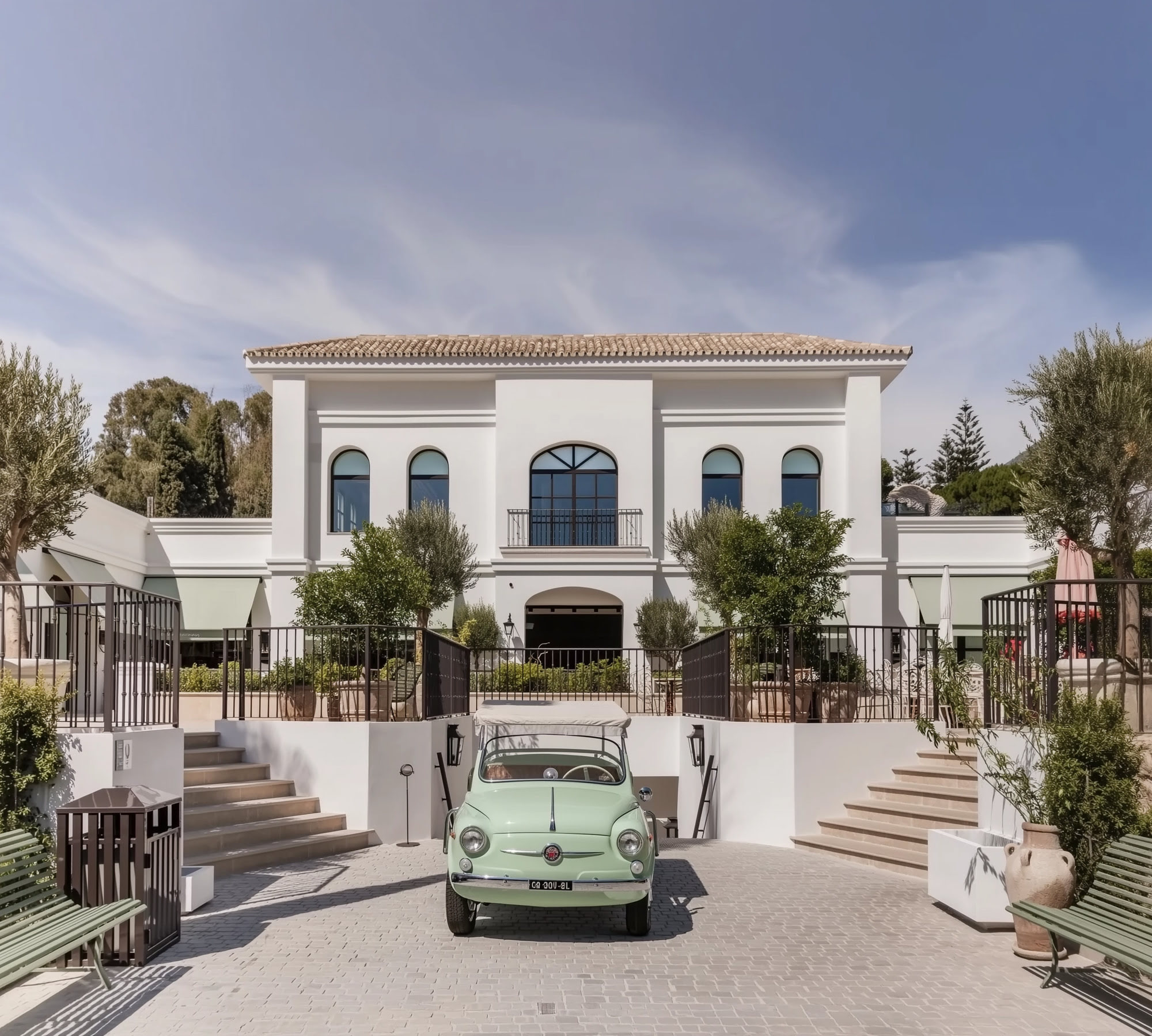 Main frontal façade of FORUM in Marbella with symmetrical composition, arched openings, awnings and formal entry character