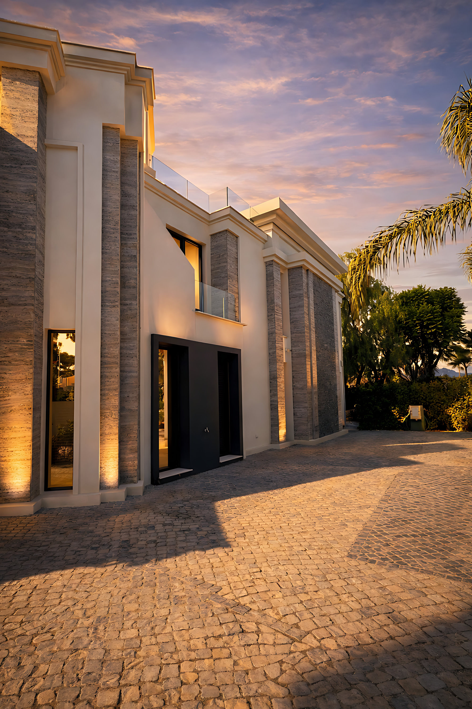 Angled exterior approach to Hillview Estate highlighting tall vertical piers, textured stone and an elegant forecourt