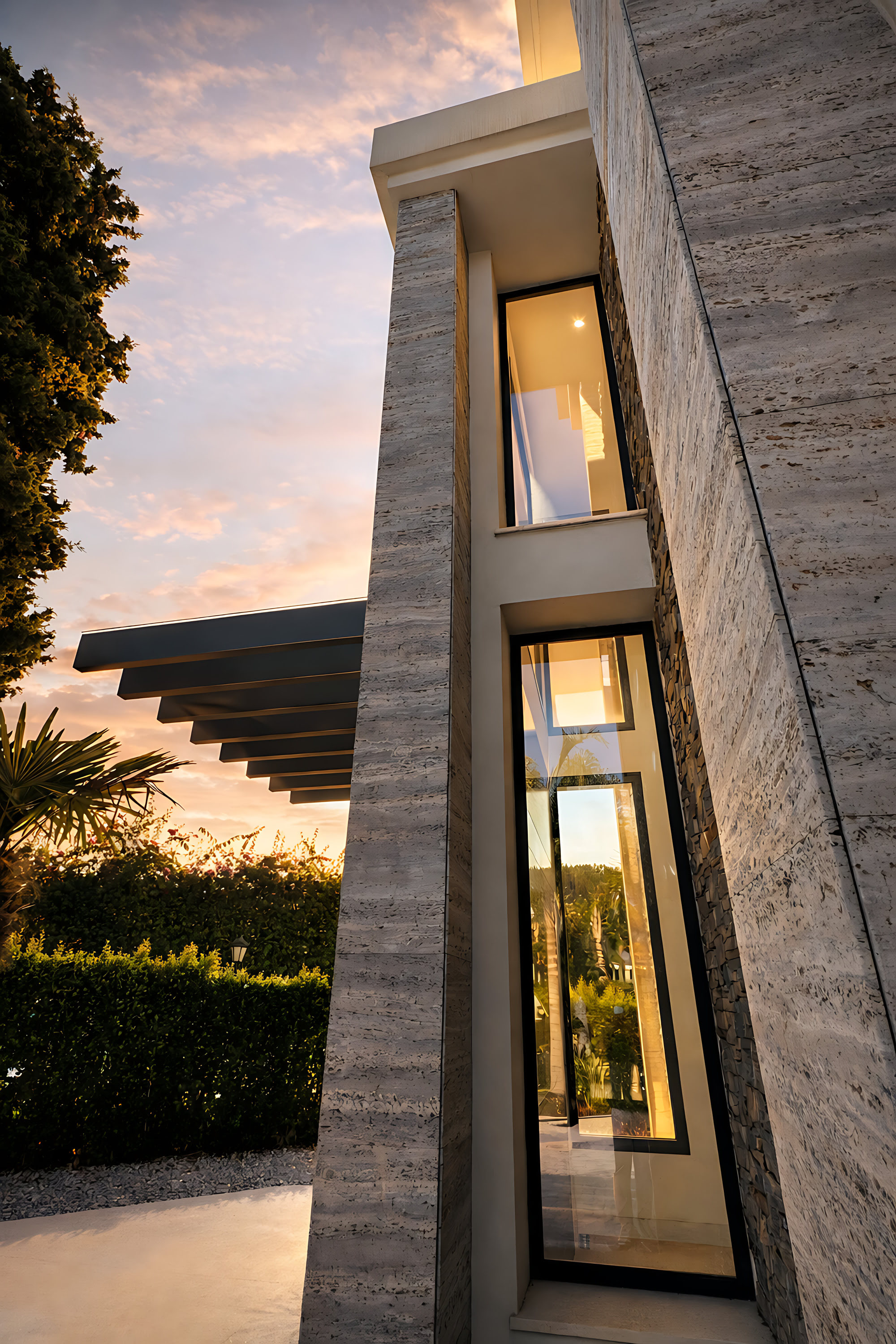 Close-up of the stone-clad entrance tower at Hillview Estate with tall glazing and sculptural proportions