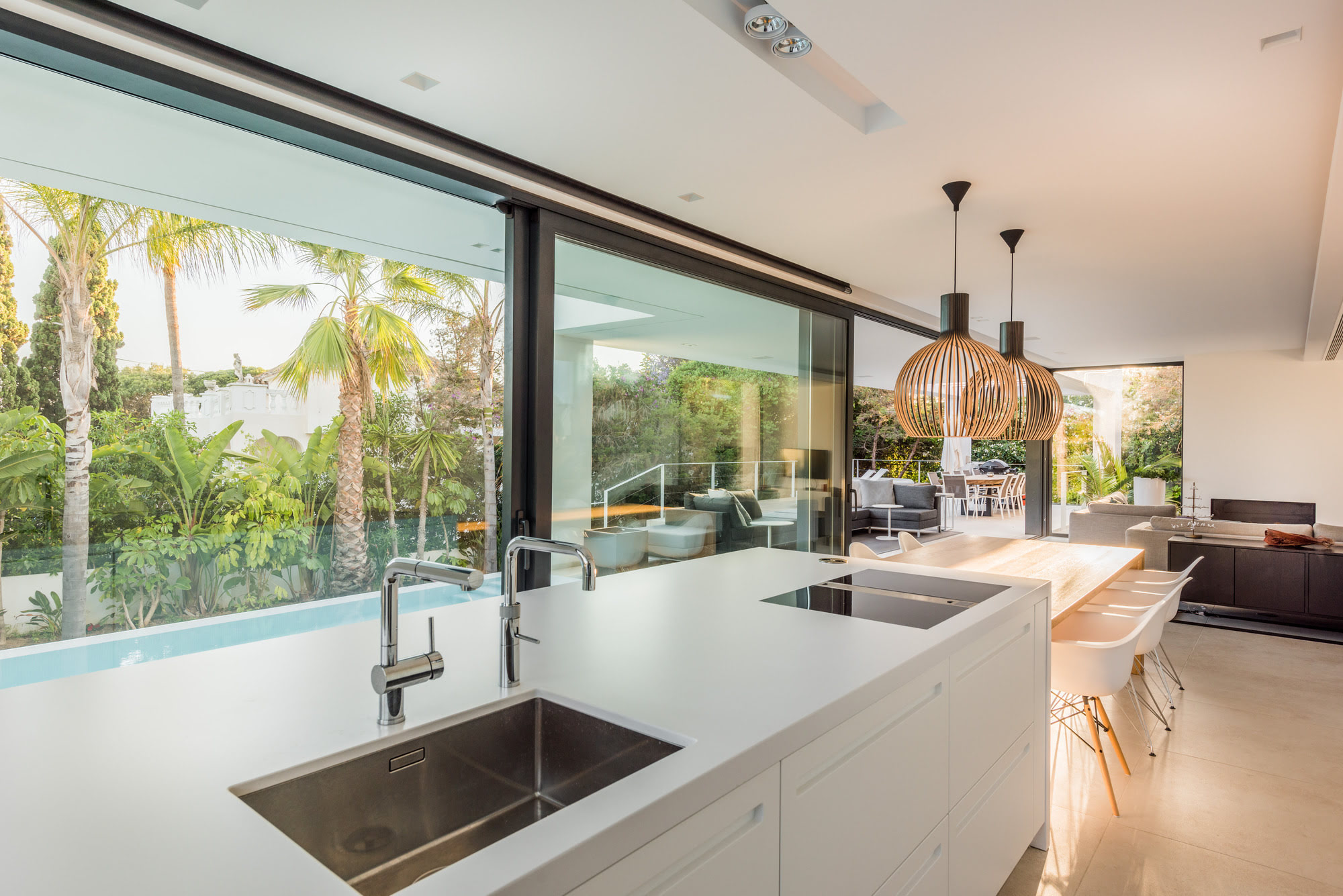 Contemporary kitchen island at M152 with wide glazing, elegant finishes and garden outlook