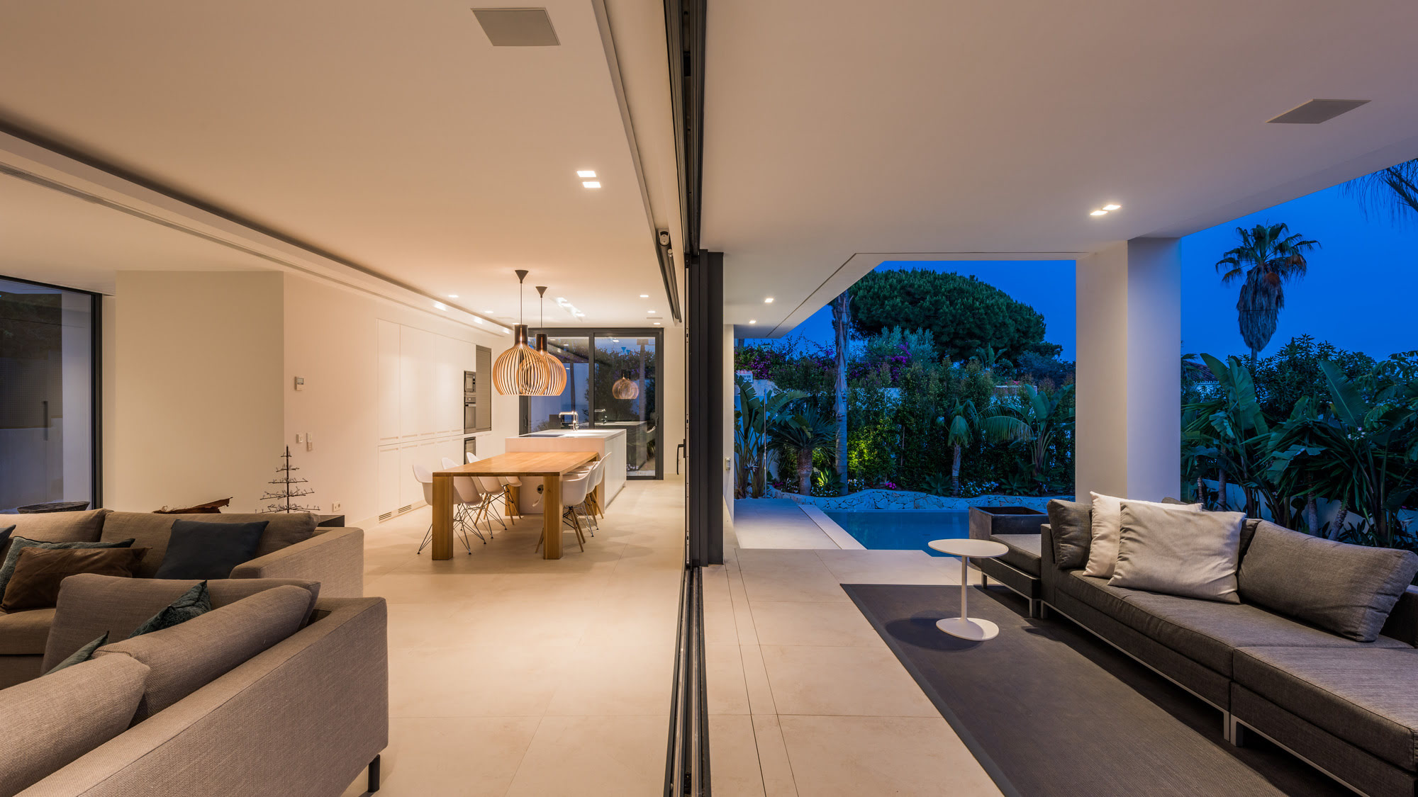 Night living room view at M152 with warm lighting, open plan layout and framed terrace outlook