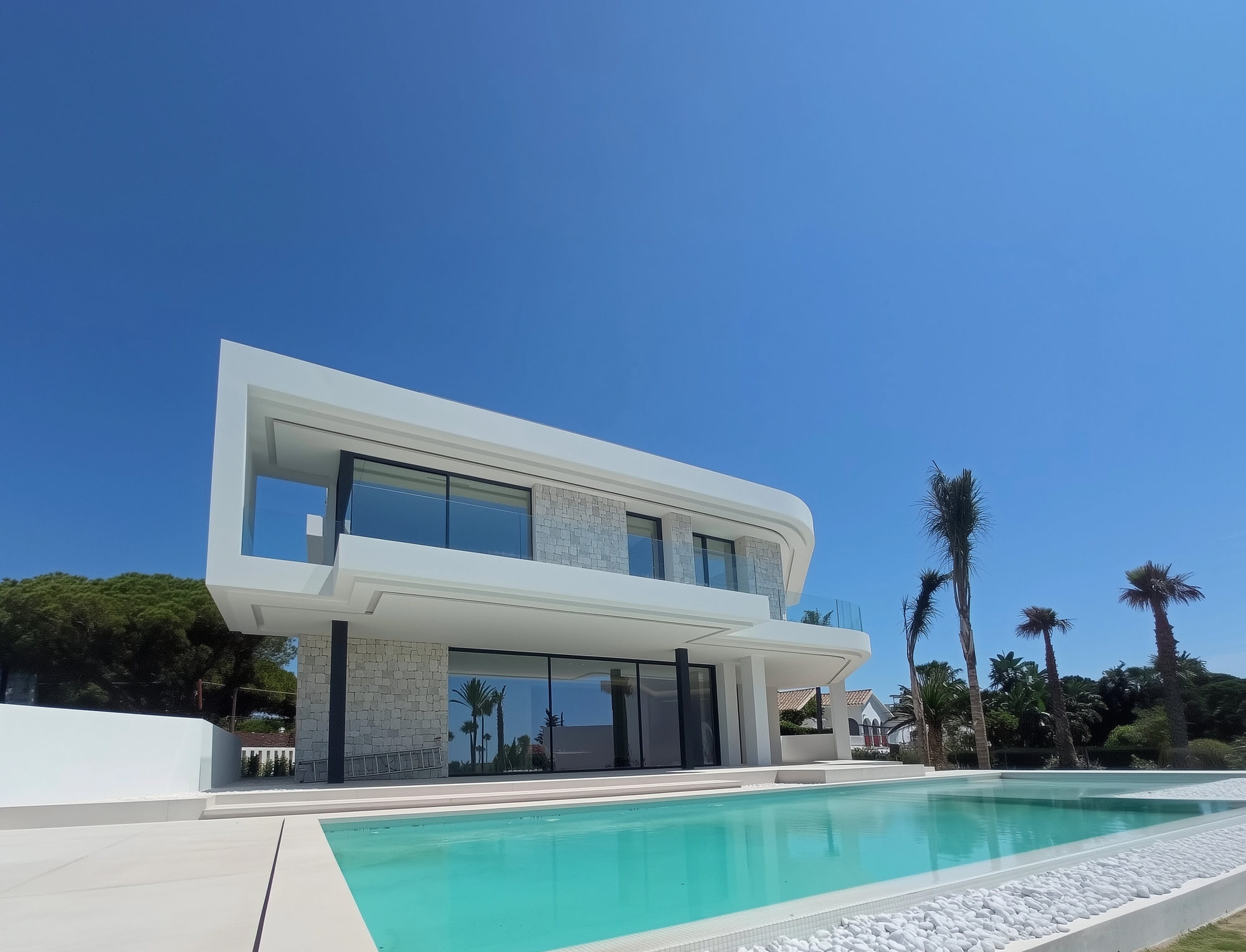 Main pool façade at M94 with sculptural white volumes, expansive glazing and panoramic terrace