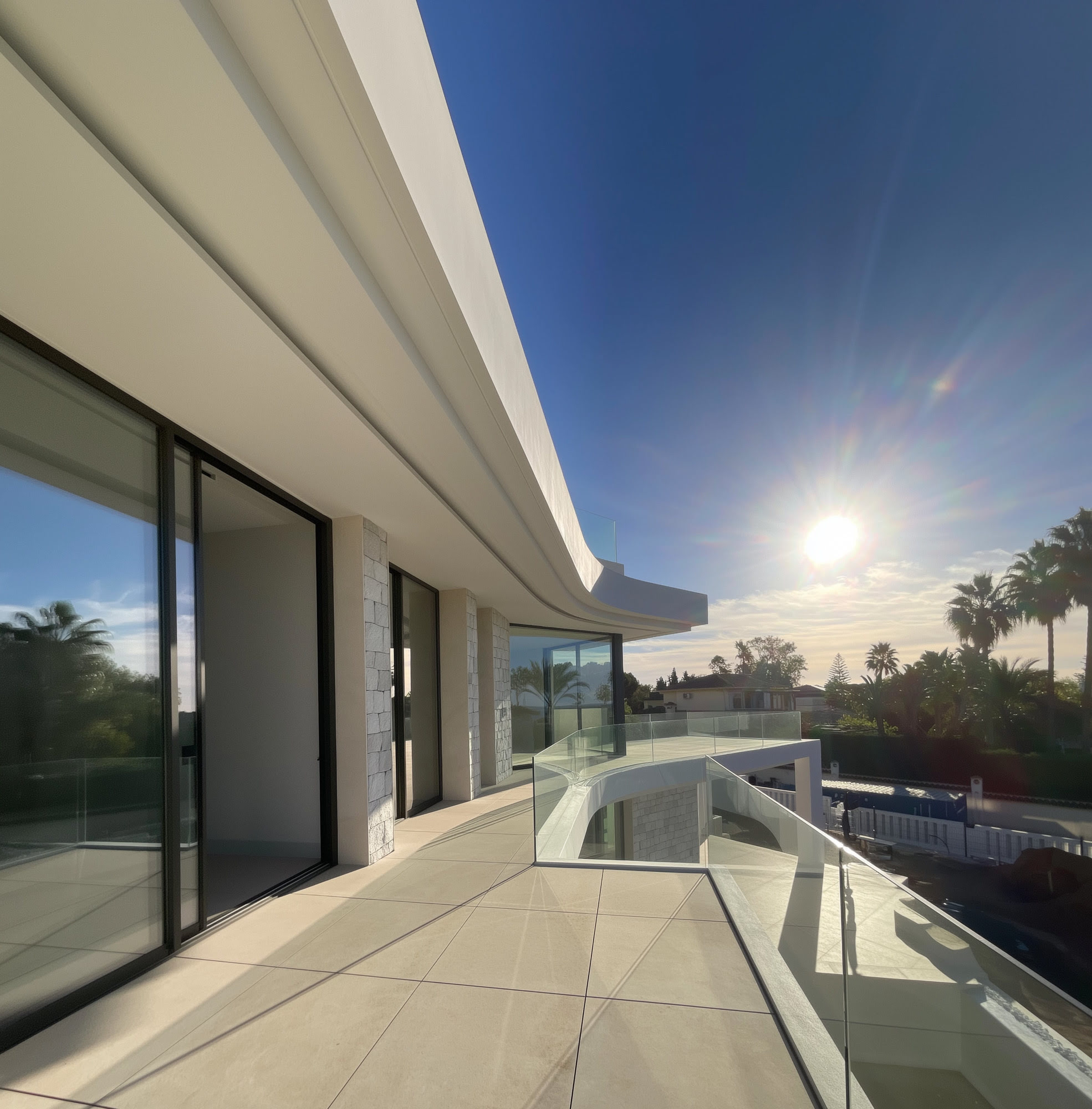 Sunset terrace view at M94 with elongated balcony, warm evening light and Marbella horizon