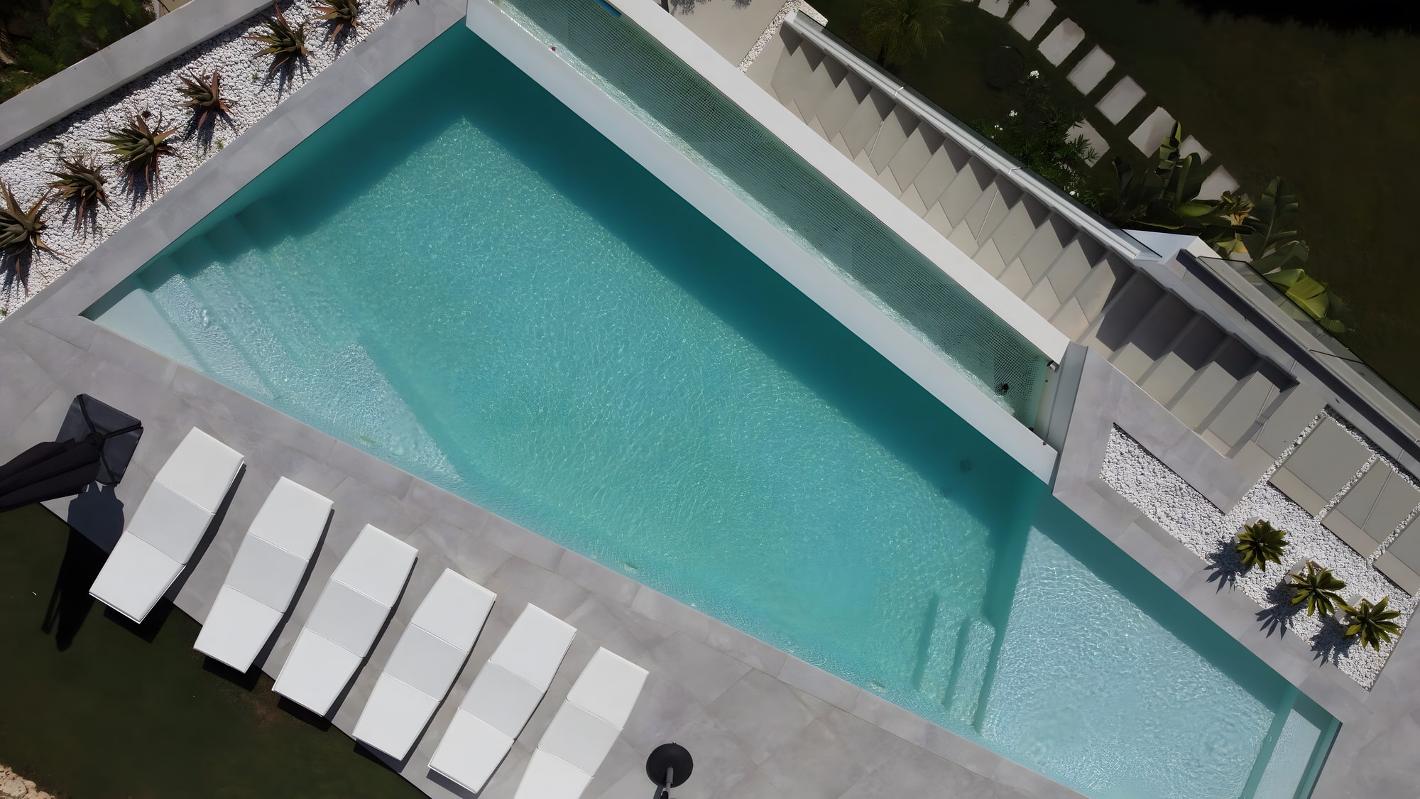 Top view of the pool composition at Villa Origami with sun loungers and crisp geometric edges
