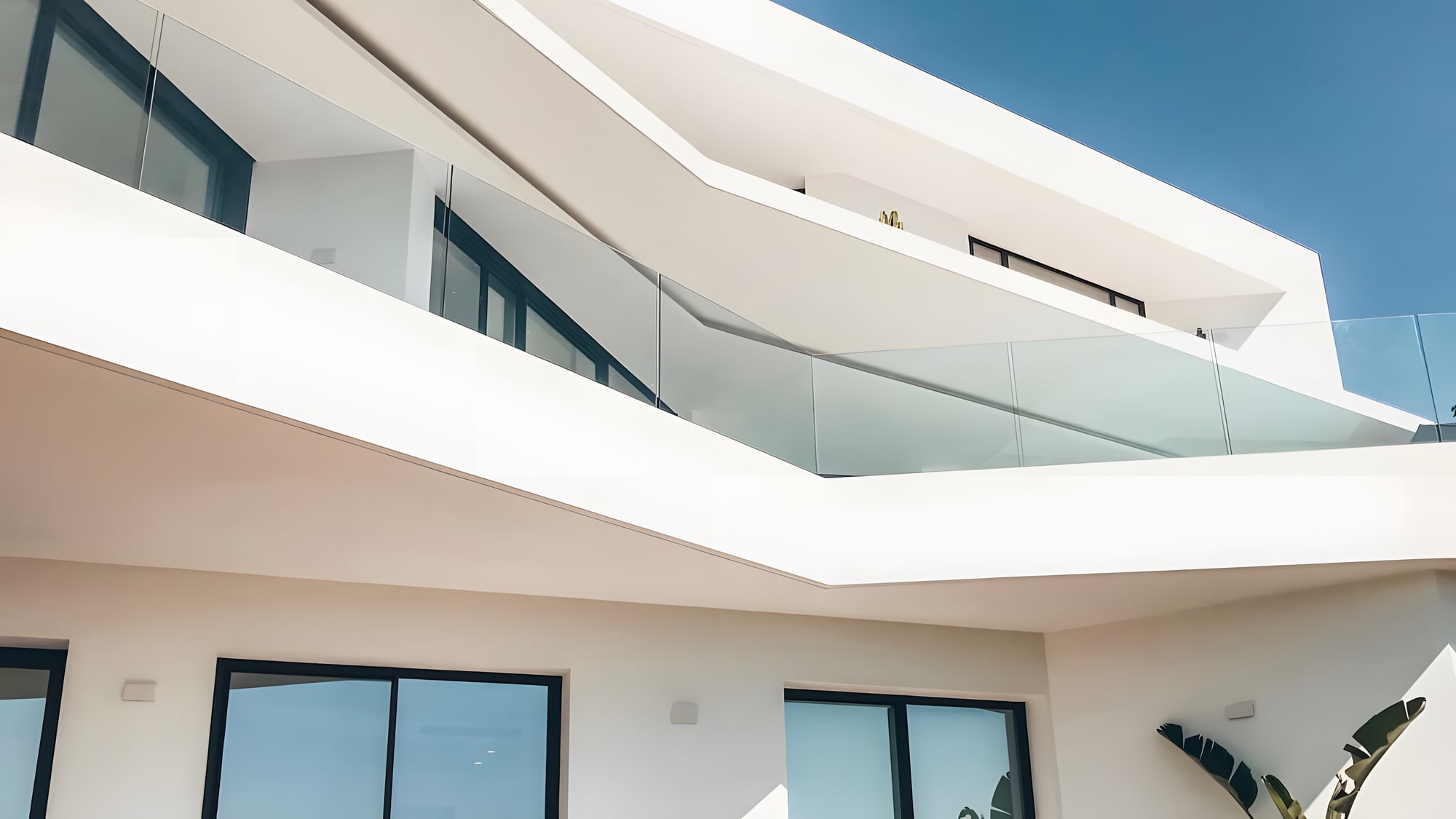 Private exterior passage at Villa Origami with curved white overhangs, planted courtyard and shadow lines