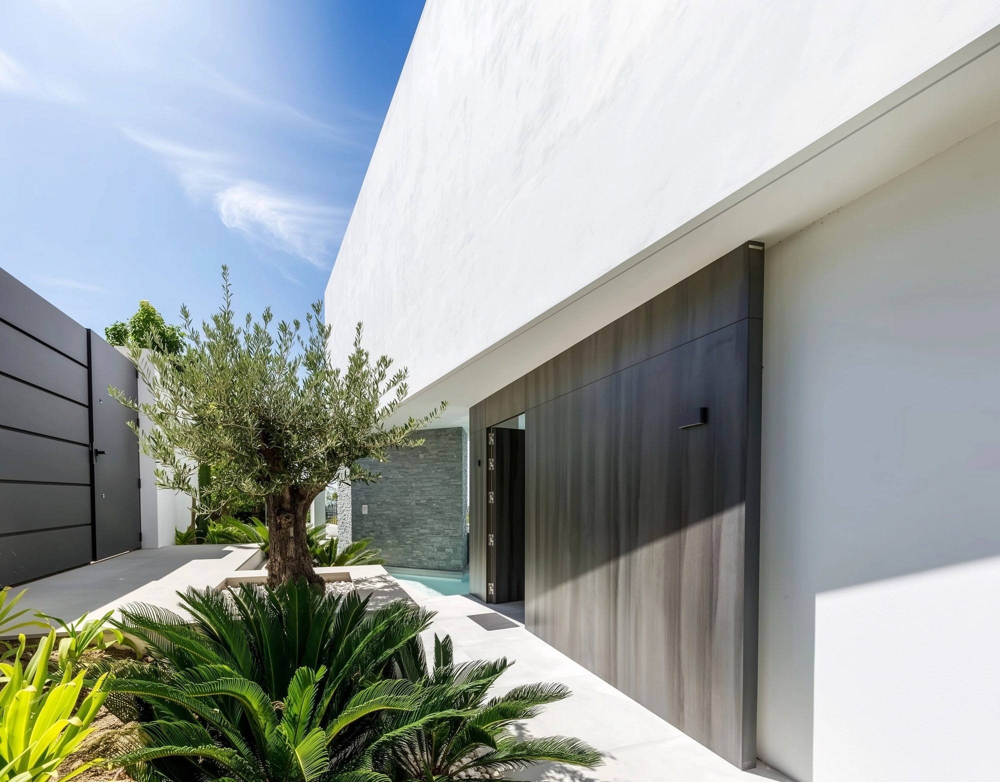 Minimalist exterior corridor at Villa Origami with white walls, planting strip and concealed openings
