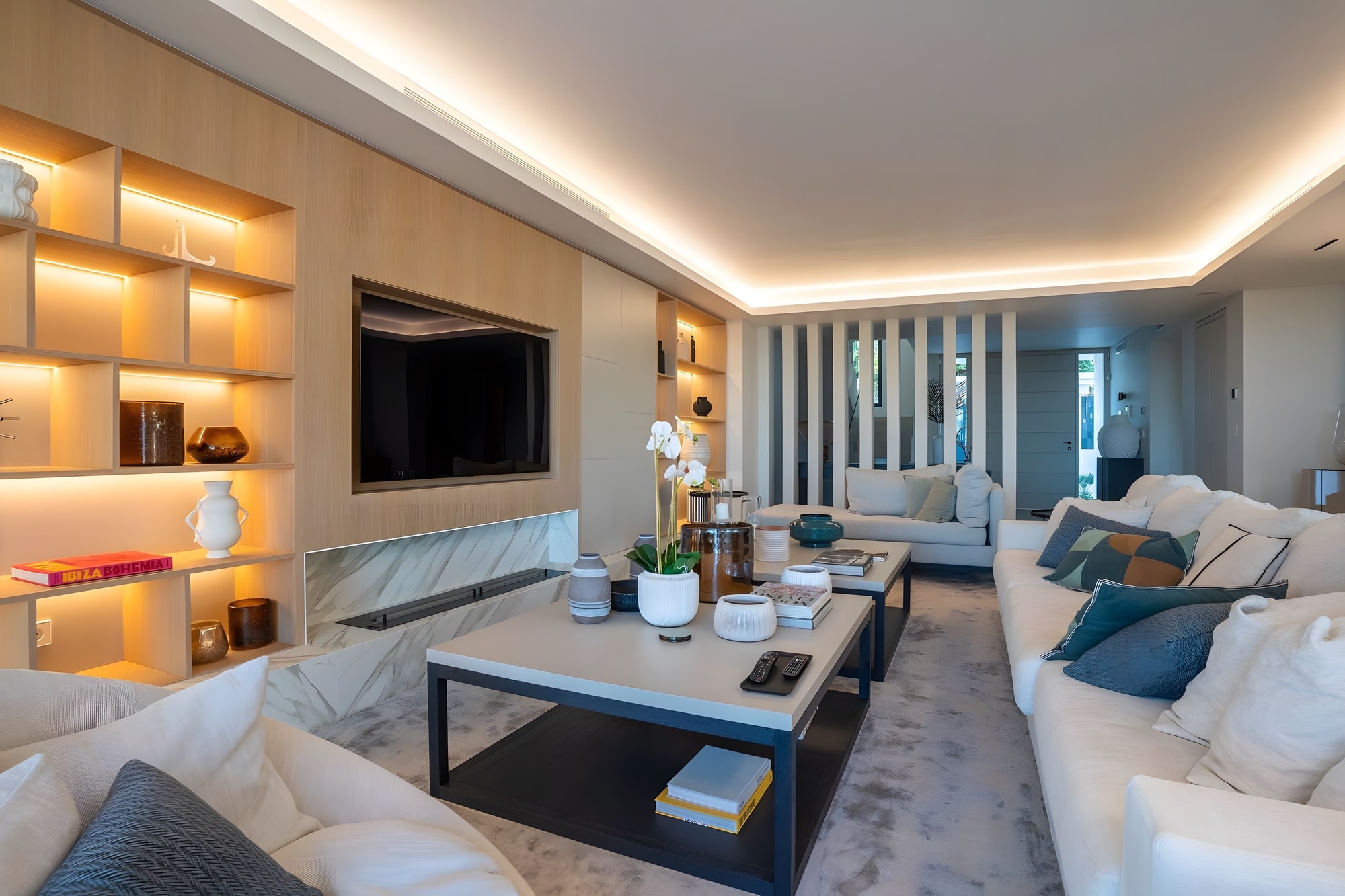 Living room with timber shelving, warm lighting and refined contemporary detailing
