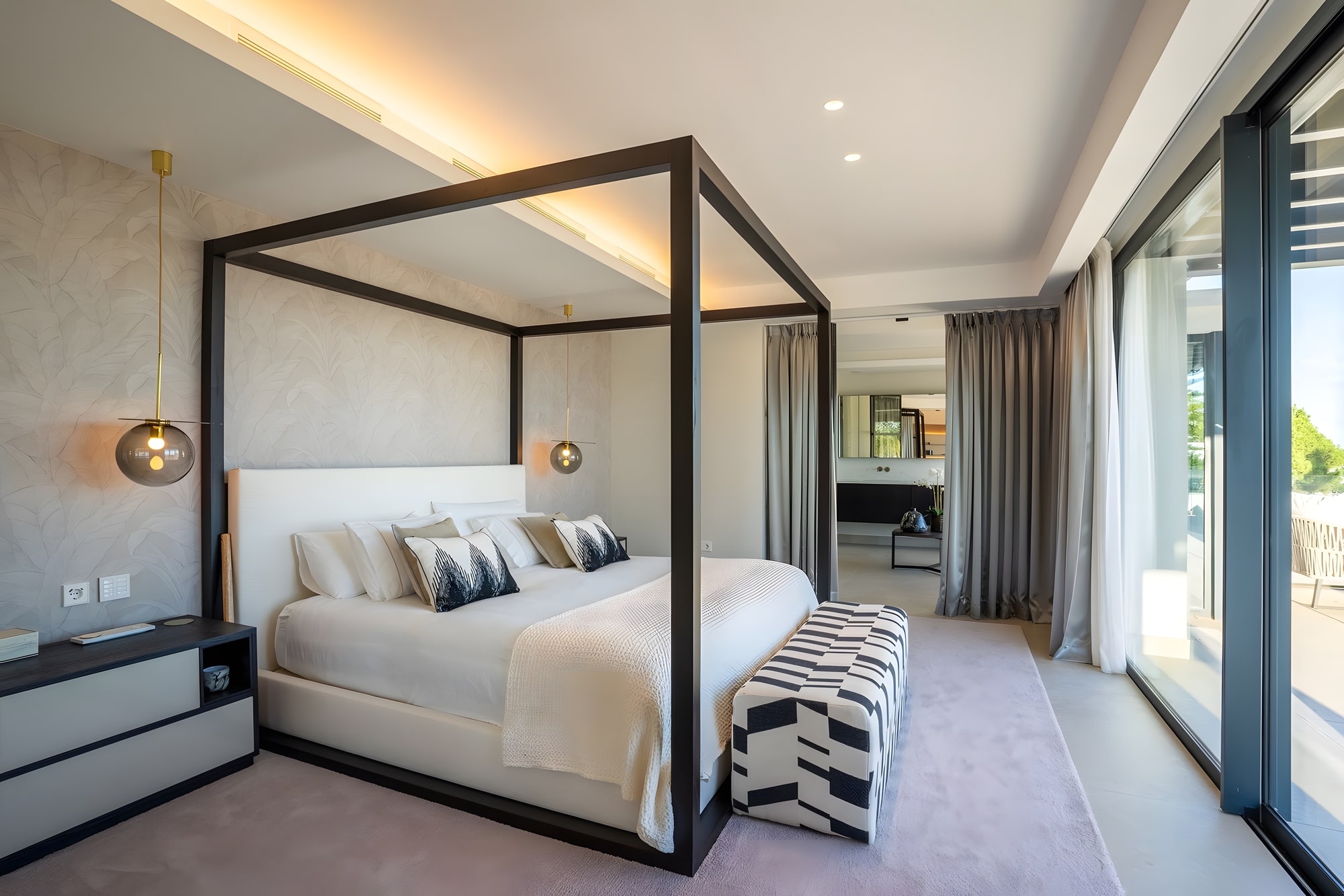 Primary bedroom with canopy bed, soft neutral palette and floor-to-ceiling glazing