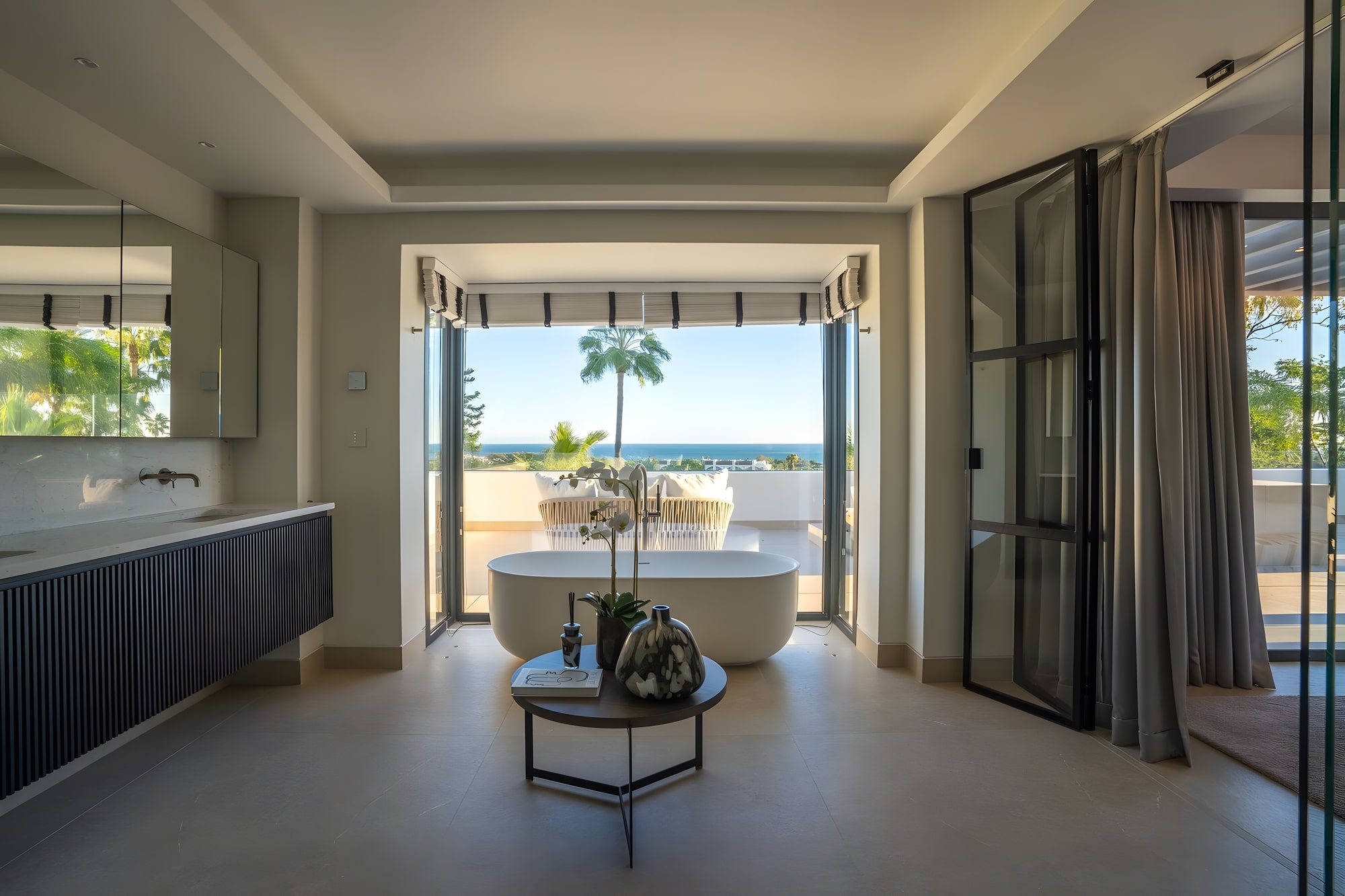 Bedroom suite with wide opening toward the terrace and distant sea views in Estepona