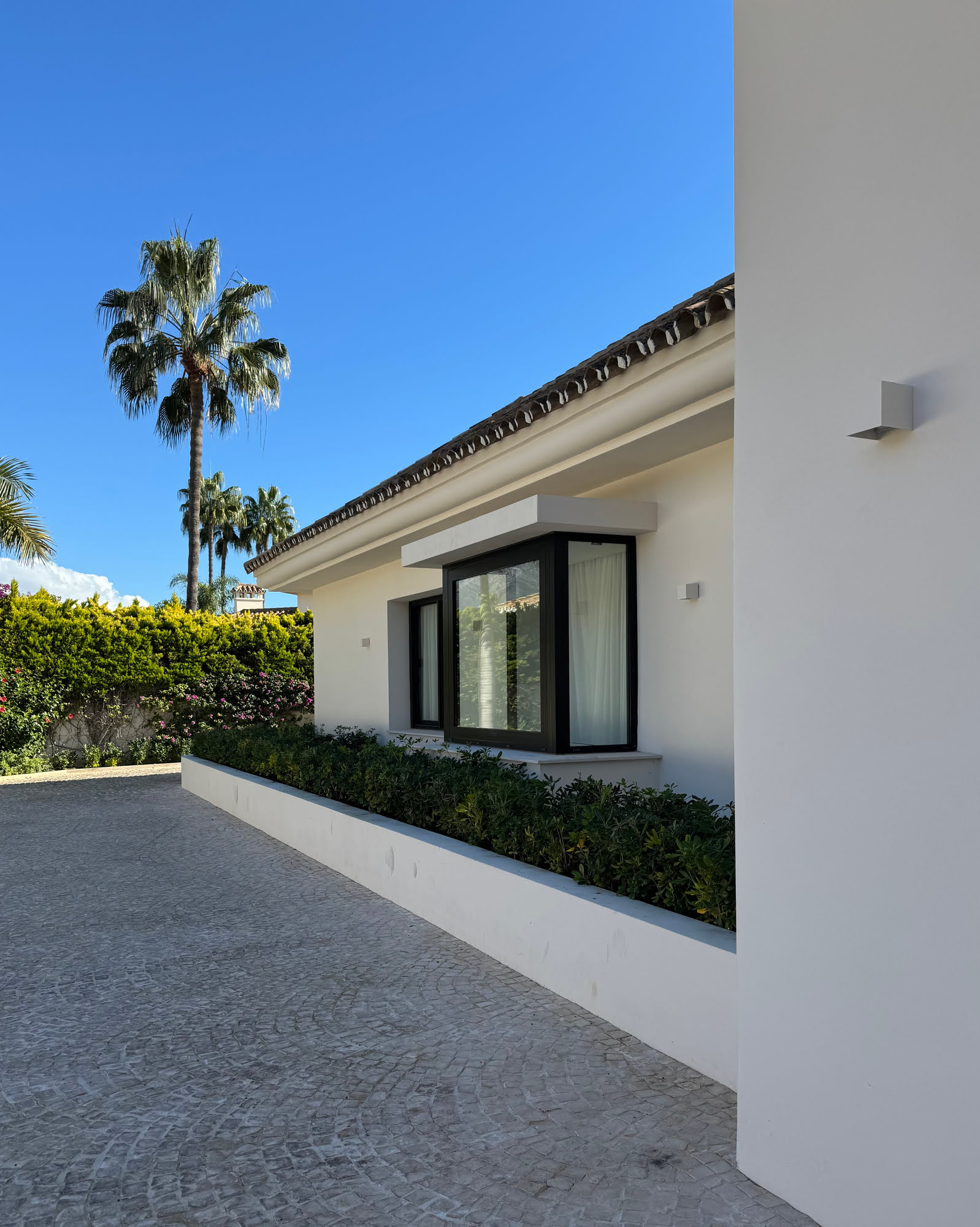 Courtyard passage between white rendered volumes of Villa Shangri-La in La Cerquilla