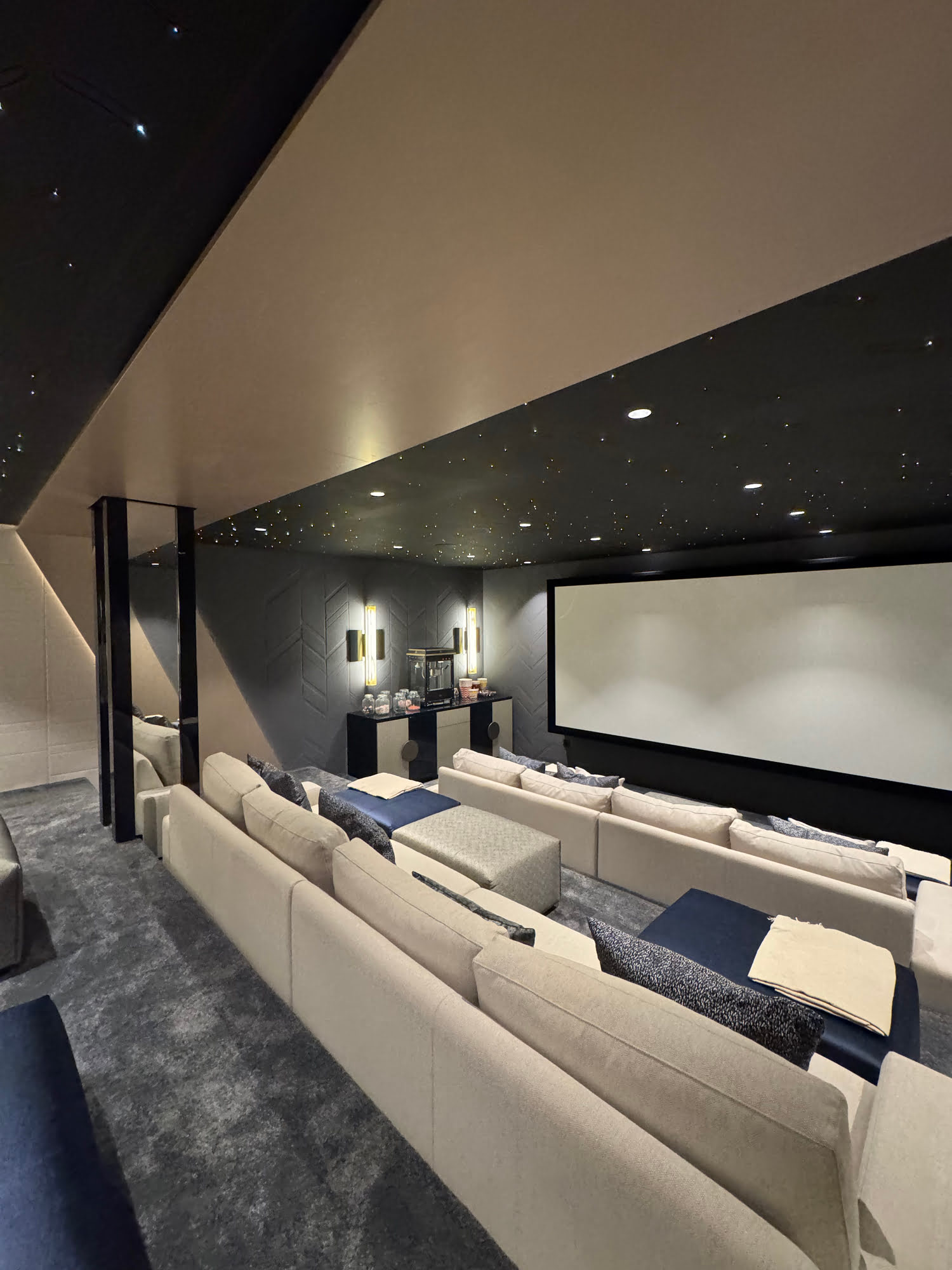 Private cinema room at Villa Shangri-La with dark finishes, projection wall and bespoke seating