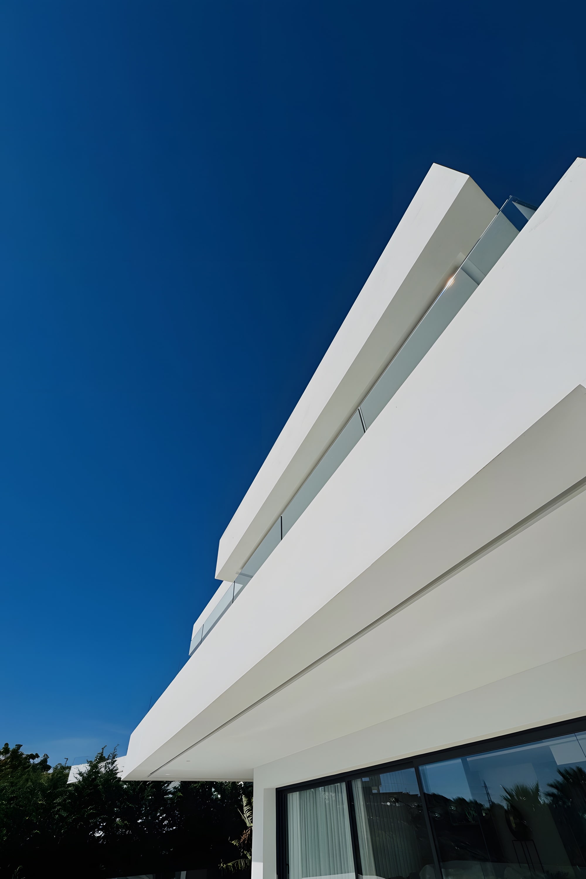 Detail of the upper façade and horizontal roofline defining the villa’s contemporary Mediterranean identity