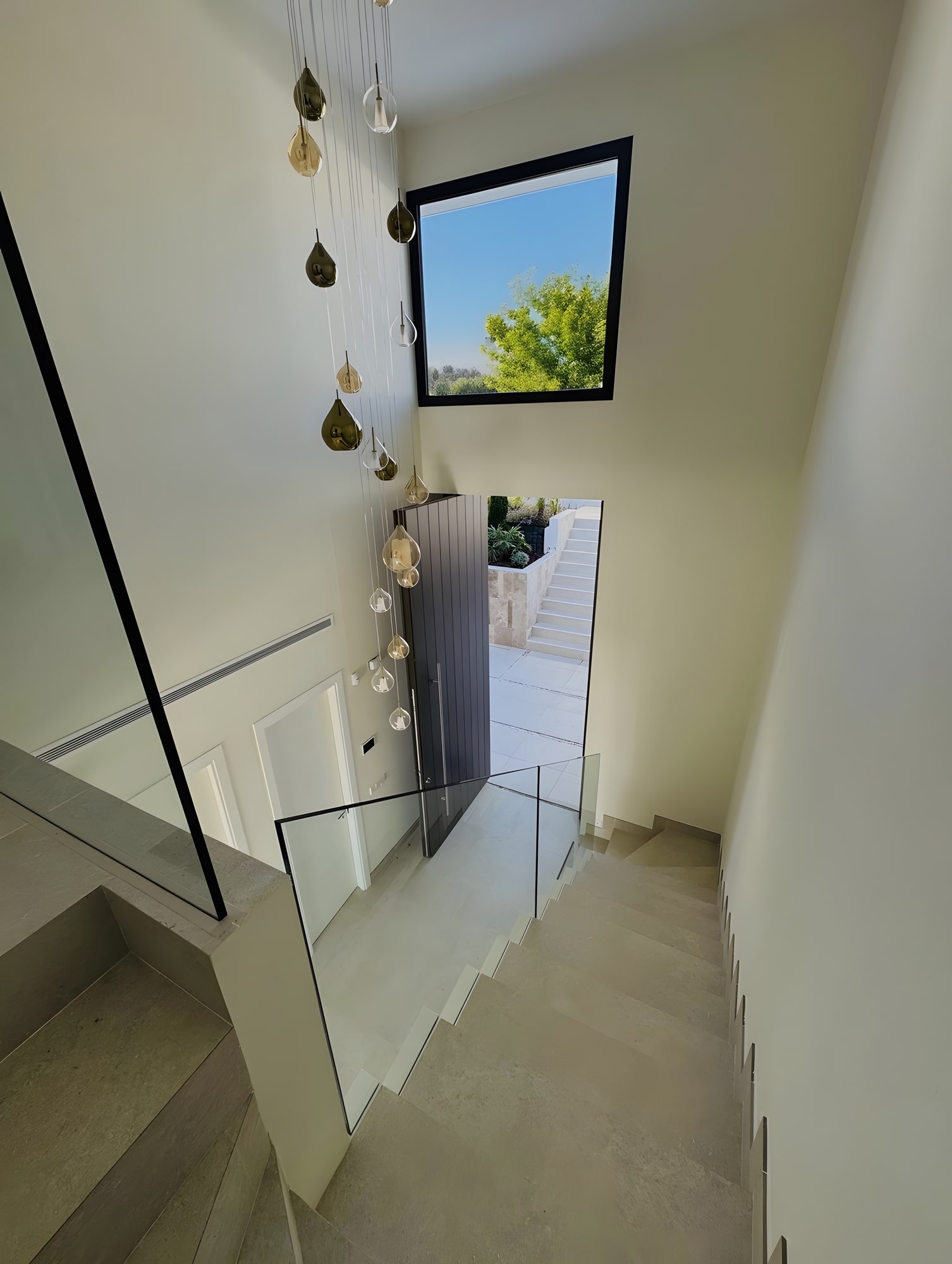 Interior staircase with top light and vertical pendant installation connecting the different levels