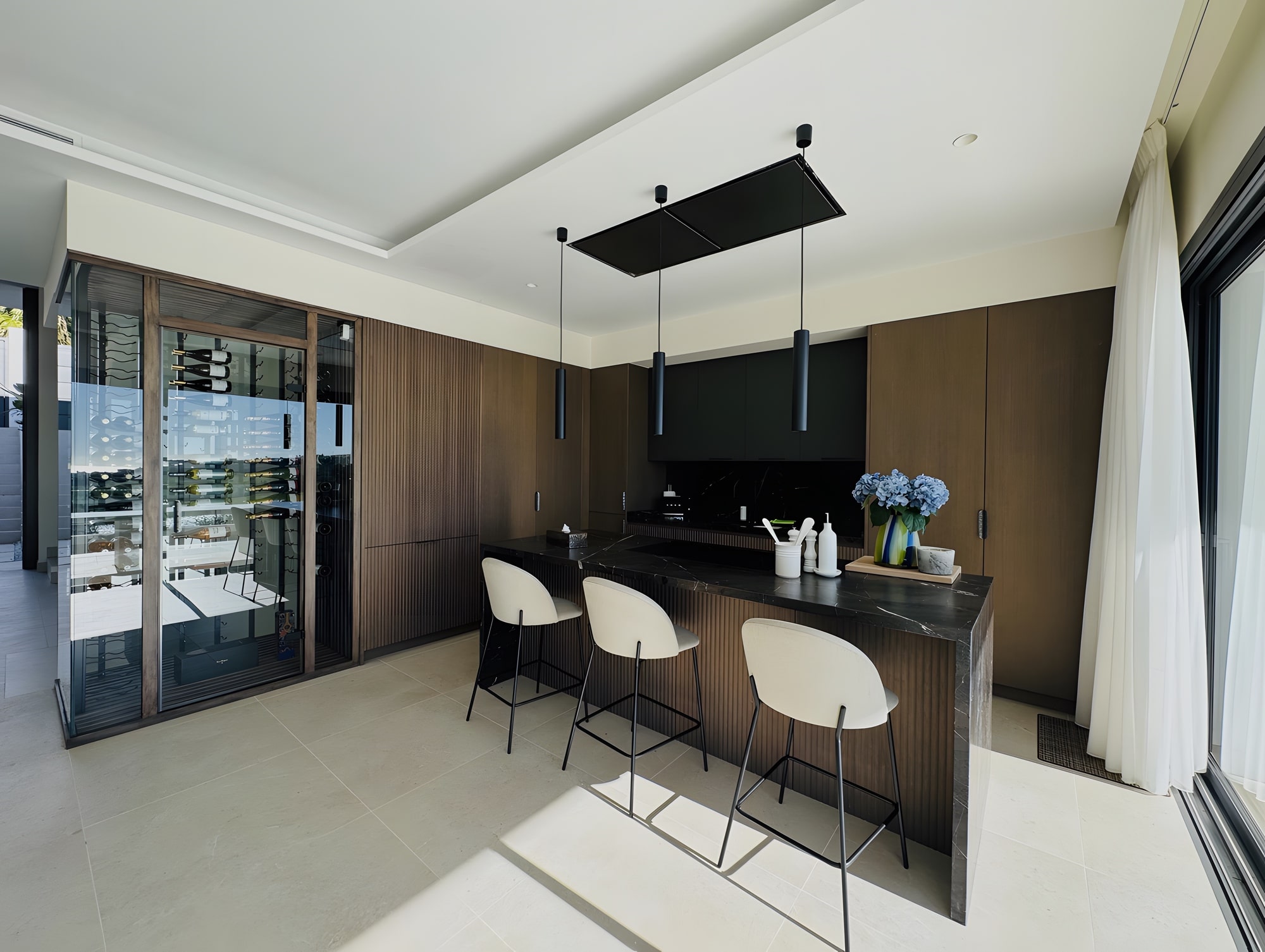 Dining space with timber cabinetry, large sliding openings and seamless connection to the terrace