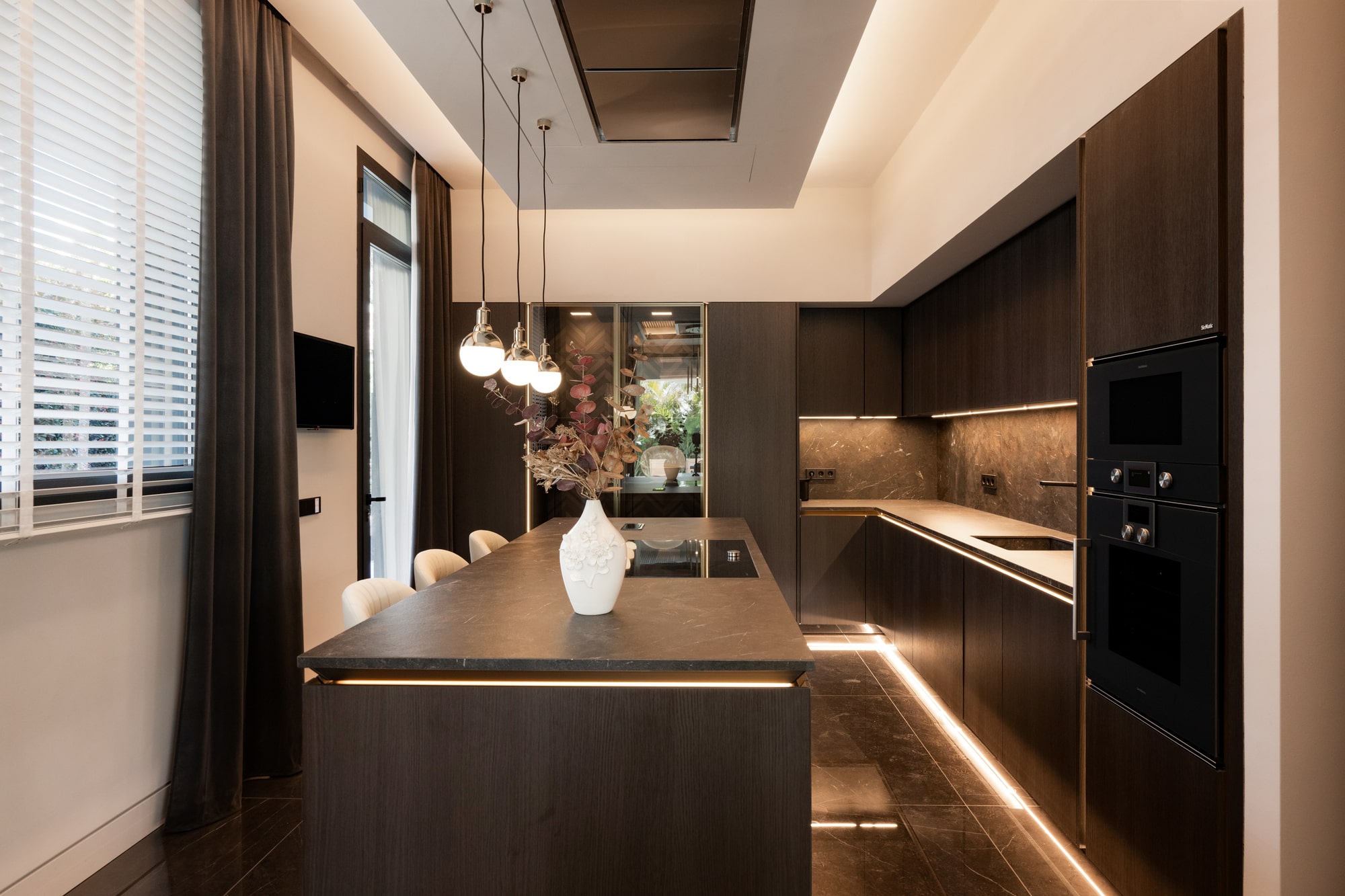 Contemporary kitchen at Casa Velázquez with integrated lighting, wood cabinetry and minimalist detailing