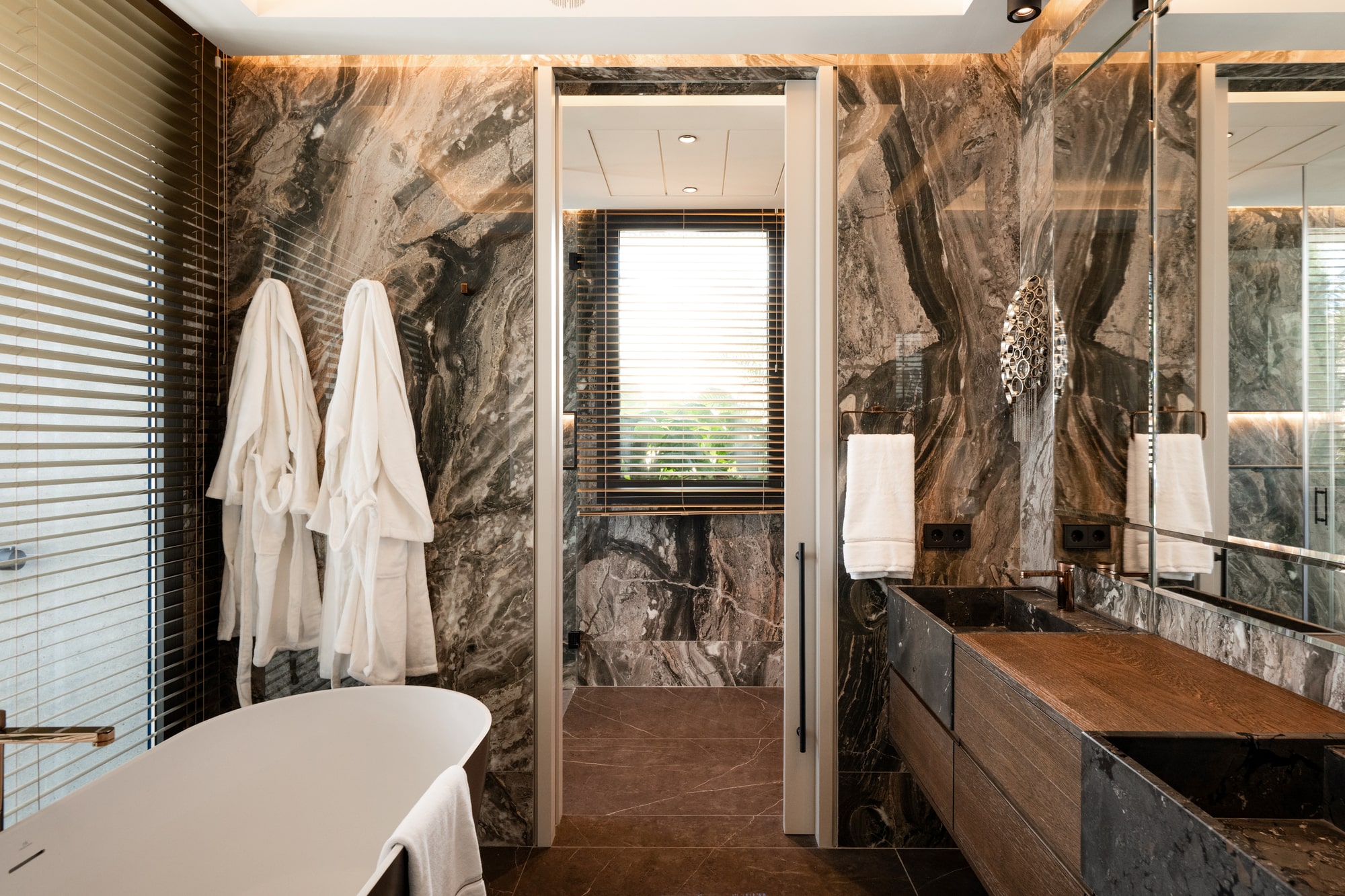 Main bathroom at Casa Velázquez with freestanding bathtub, natural stone walls and balanced daylight composition