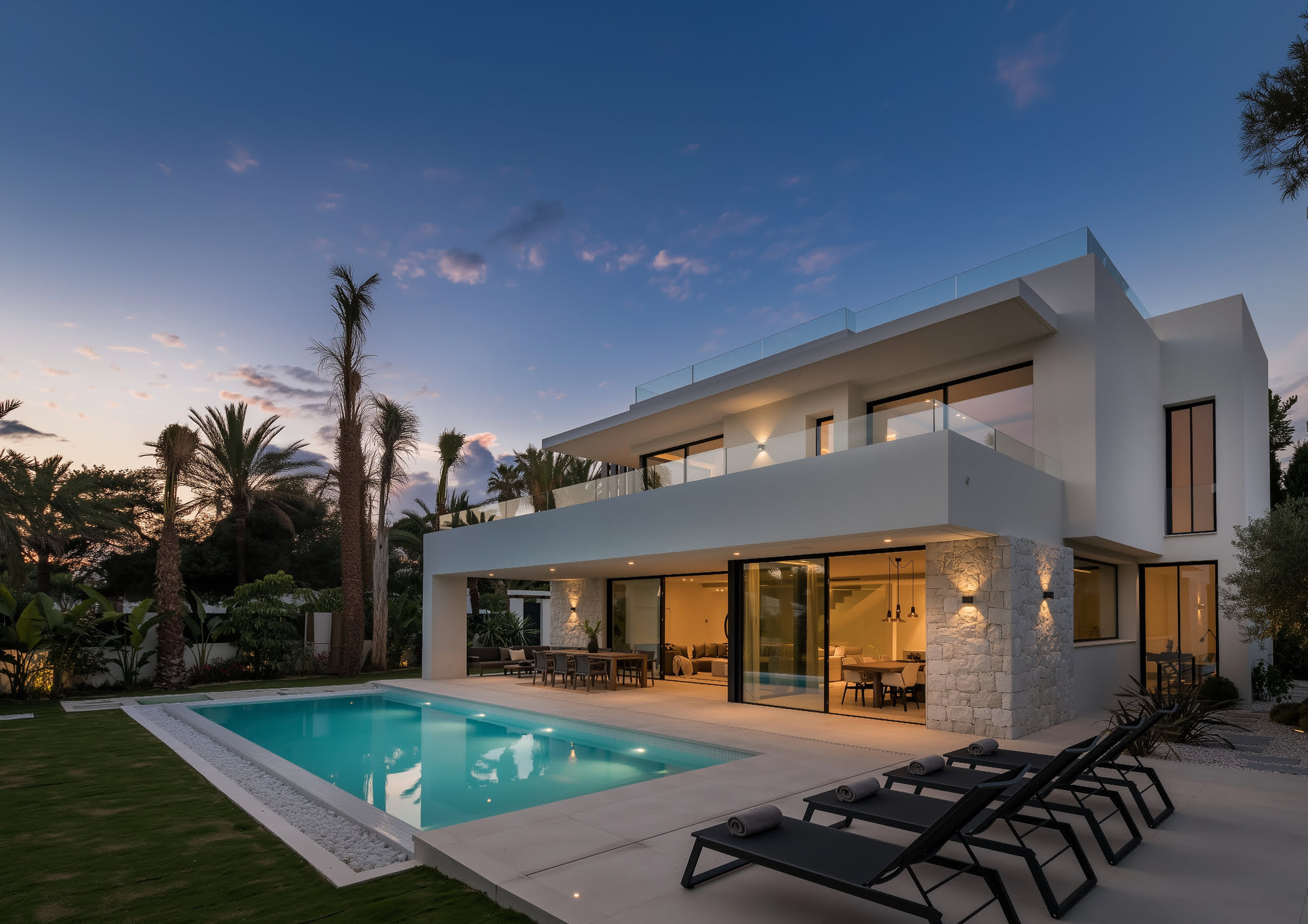 Twilight exterior of VIDA DEL MAR with illuminated pool, calm proportions and warm evening atmosphere