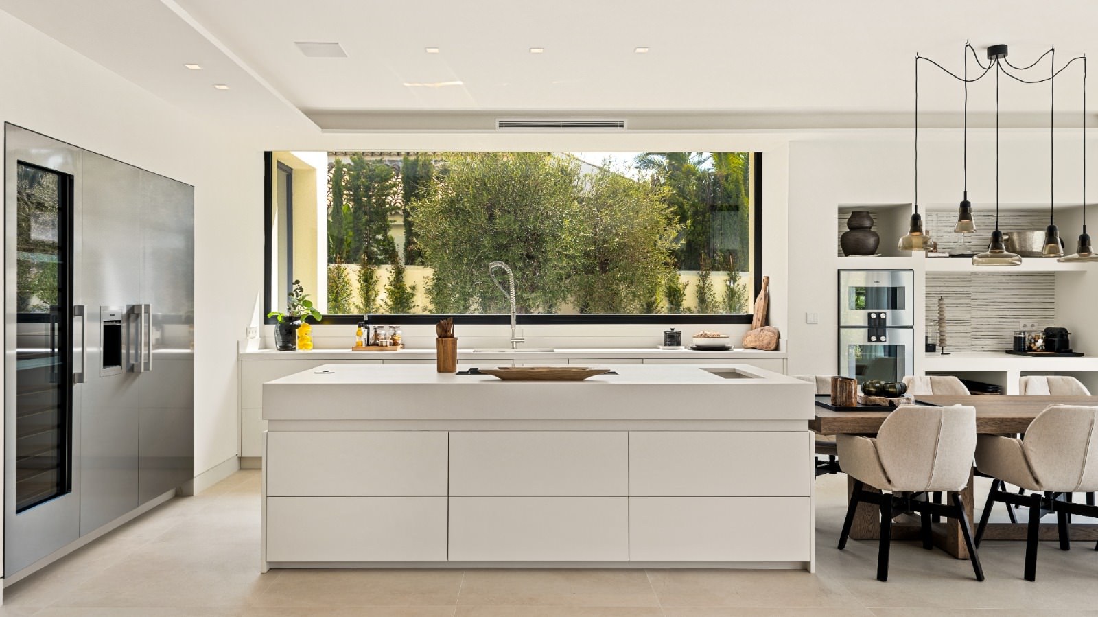 Kitchen and dining view at VIDA DEL MAR with island workspace, warm joinery and full-height glazing