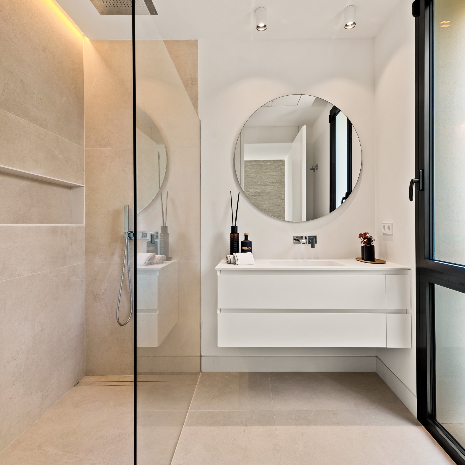 Secondary bathroom at VIDA DEL MAR with glass shower, pale stone surfaces and elegant natural light