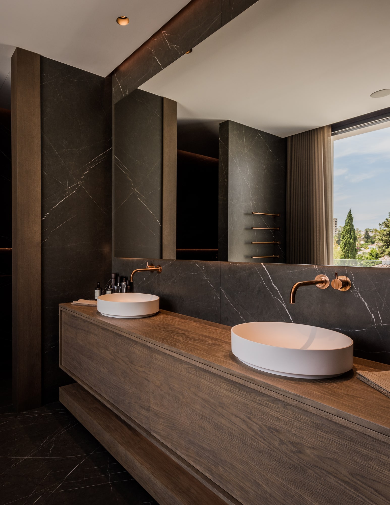 Bathroom vanity at Villa Zarina with stone countertop, vessel basins and a refined palette of timber and bronze tones