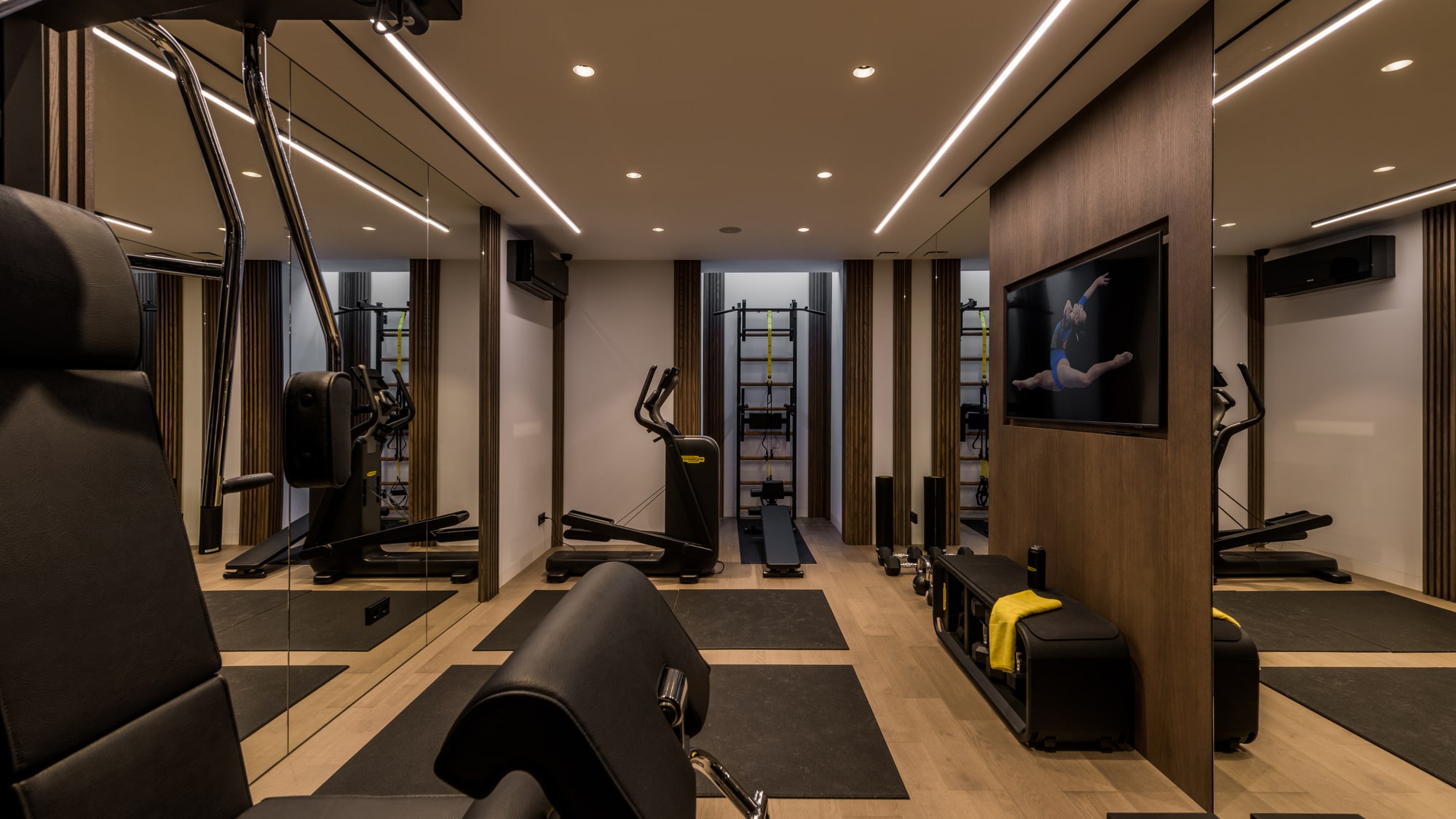 Private gym at Villa Zarina with mirrored walls, integrated lighting and bespoke wellness-focused interior design