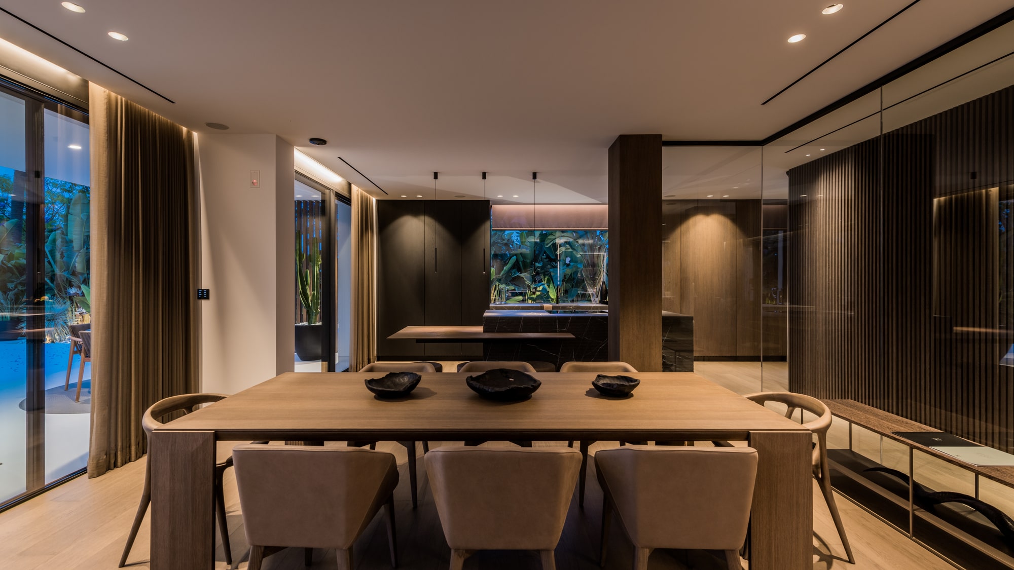 Evening dining room at Villa Zarina with warm architectural lighting, textured finishes and a refined indoor gathering space