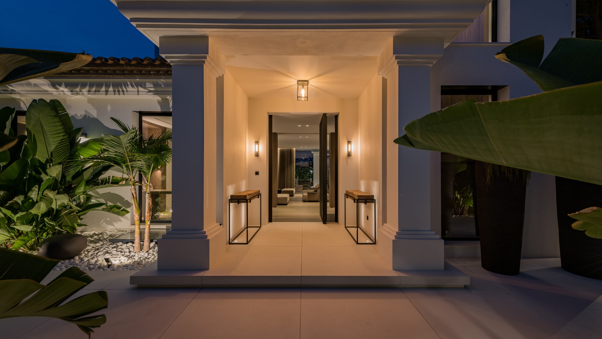 Evening arrival view of Villa Zarina in La Cerquilla, with illuminated entrance portico, symmetrical approach and warm architectural lighting